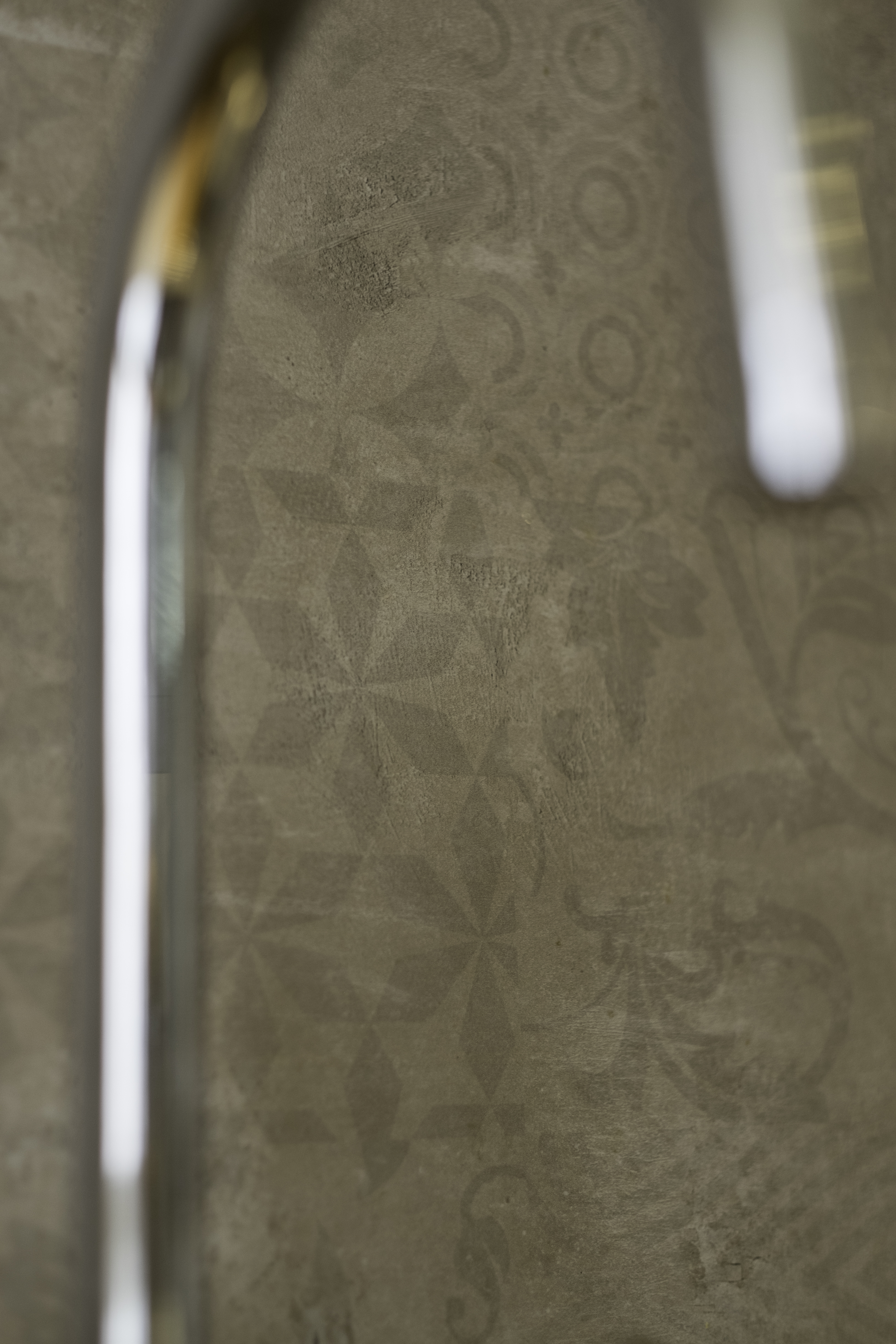 Subtle grey-brown geometric & floral tile wall.