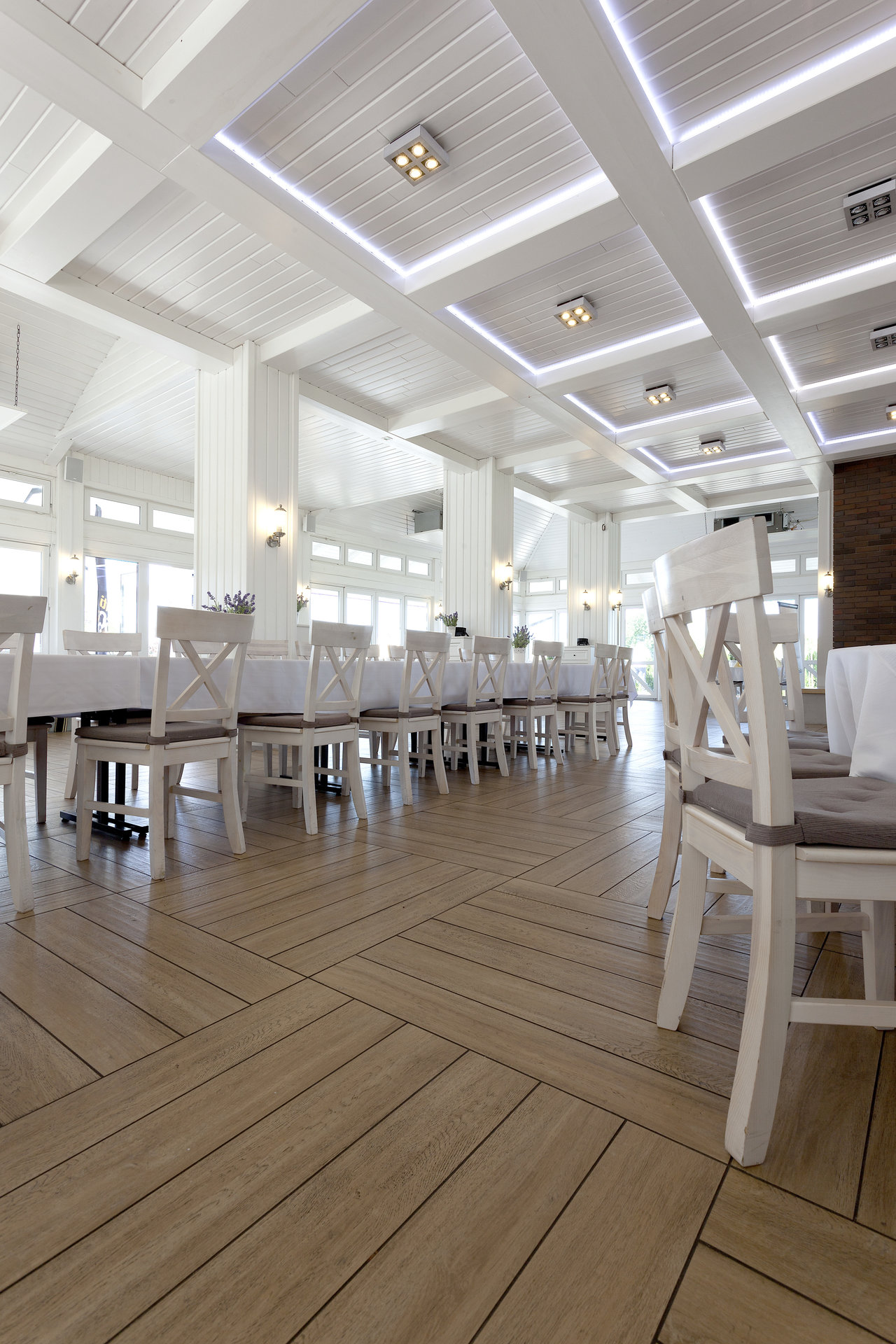 Elegant wood-effect herringbone tiles in a stylish restaurant.