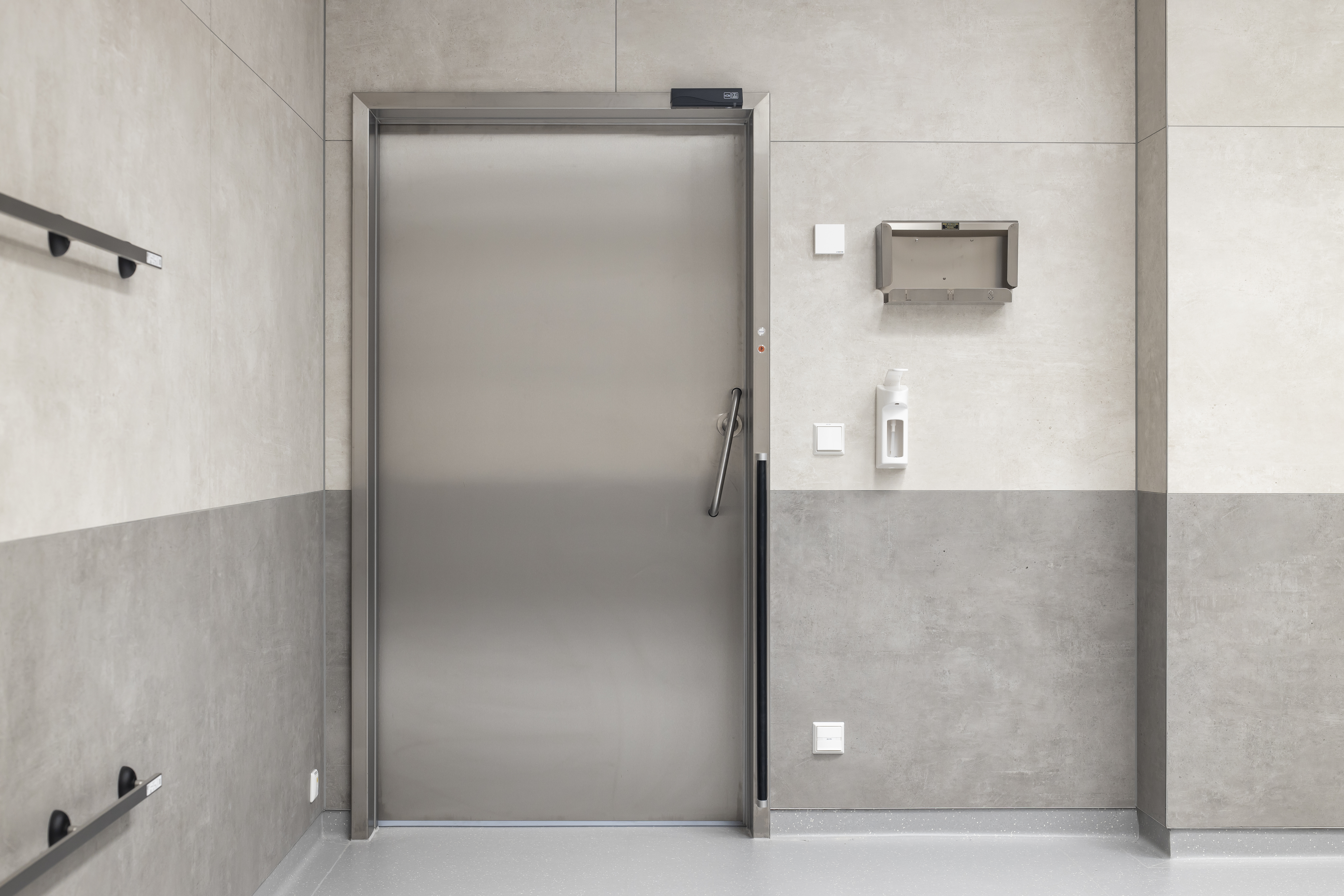 High-quality grey and white wall tiles with concrete look in a modern hallway.