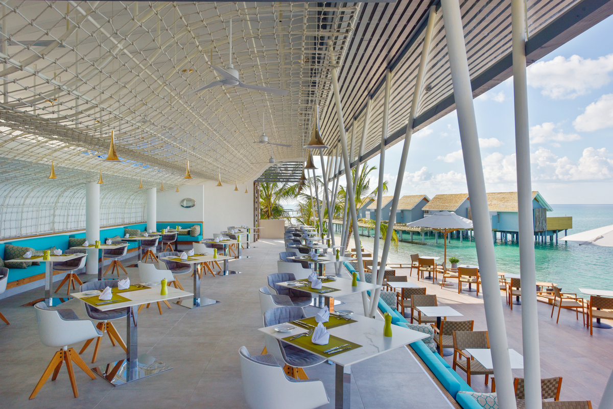 Modern restaurant with sea view and bright, large-format tiles.