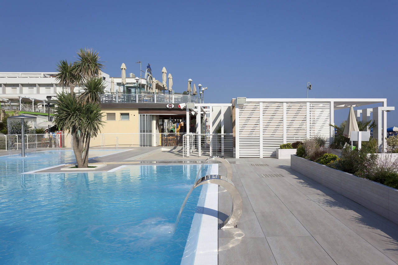 Modern grey outdoor tiles at pool with stylish pergola.