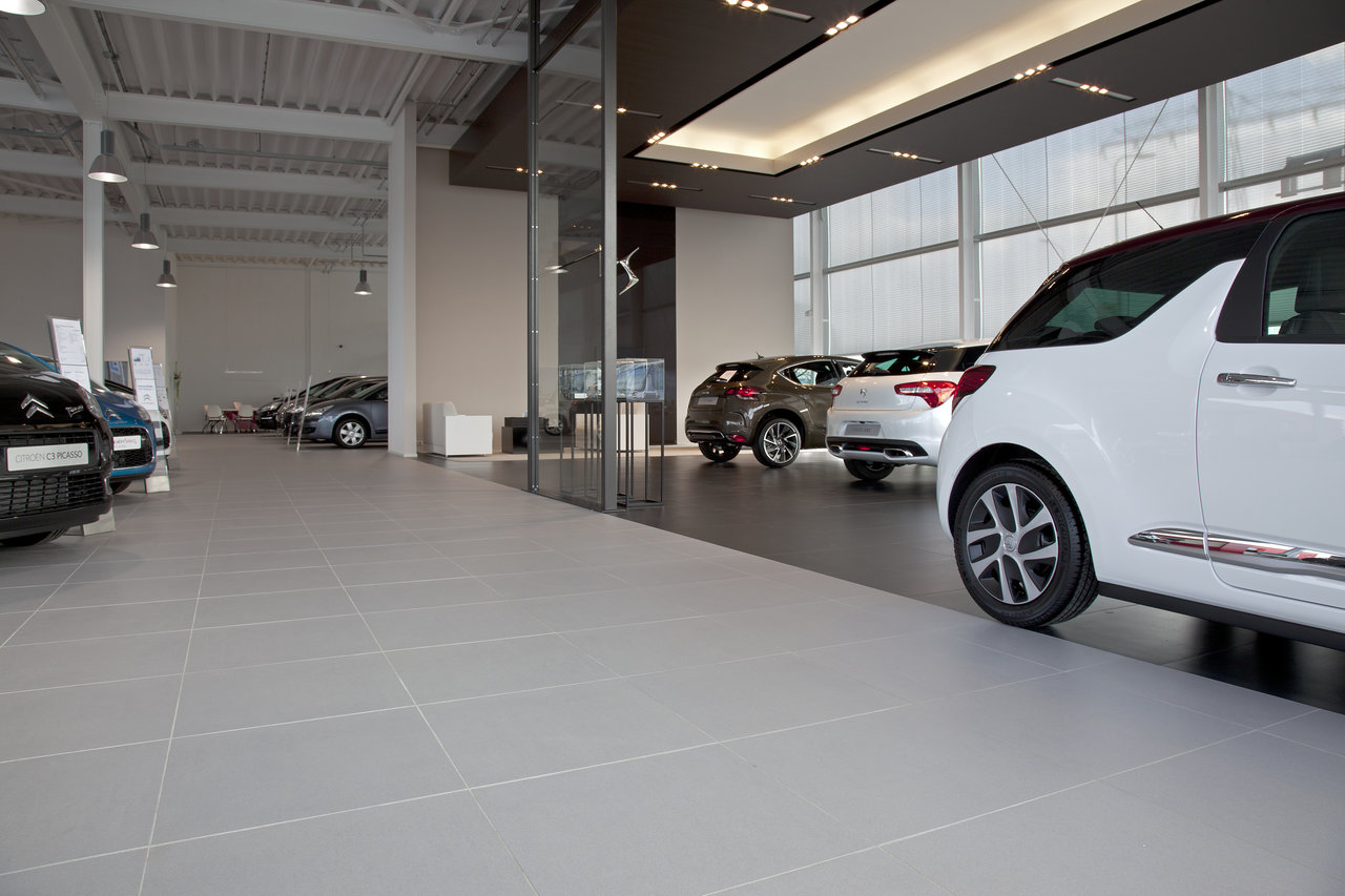 Bright, robust tiles in car showrooms – ideal for high-traffic indoor spaces.