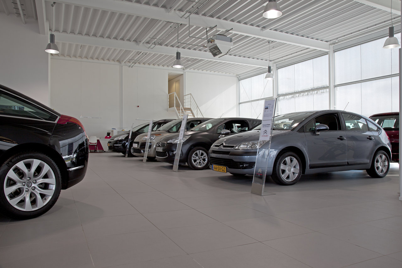 Large-format, light grey tile flooring for commercial indoor areas, ideal for car showrooms.