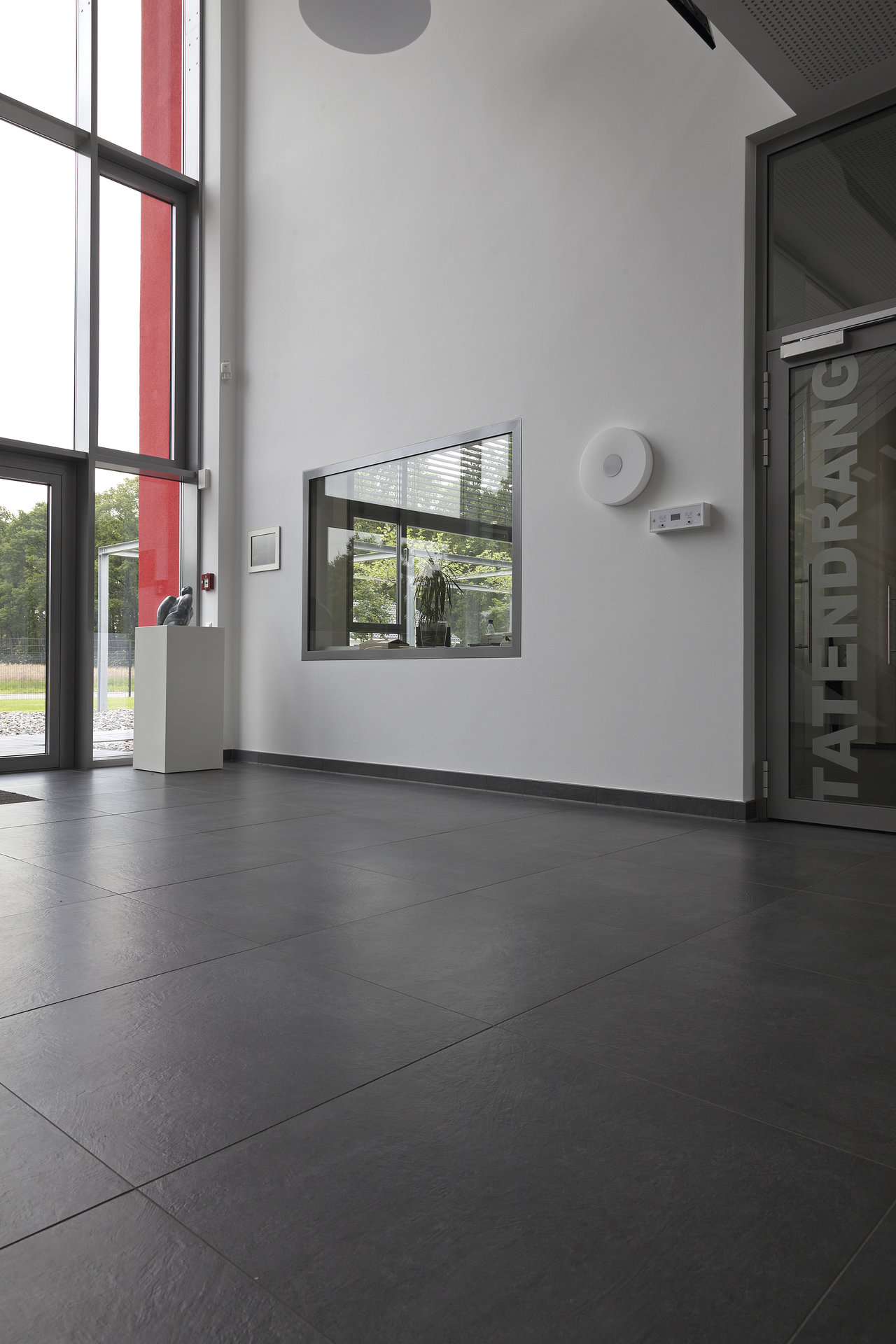 Large-format, dark grey floor tiles in a modern entrance area.