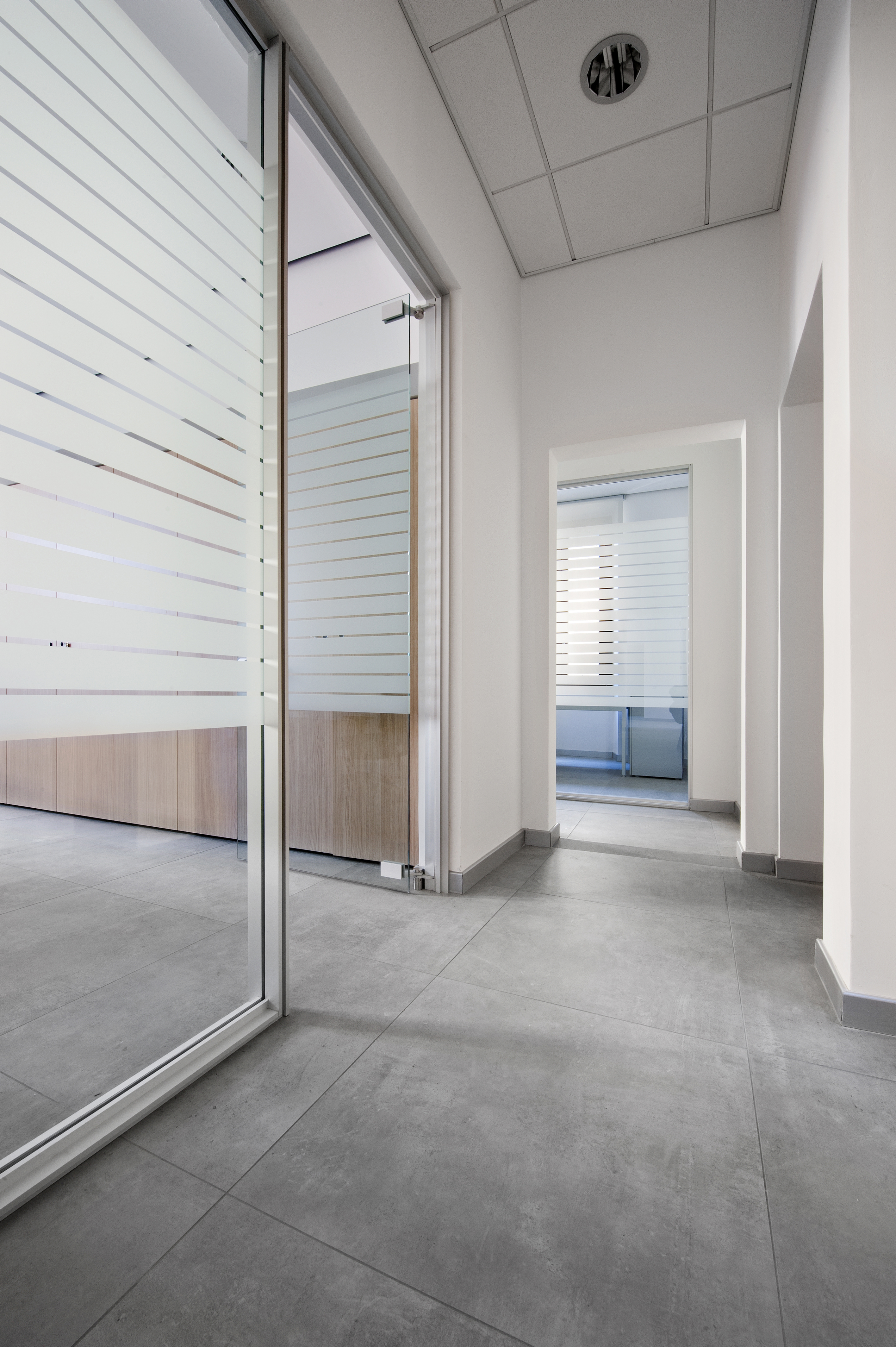 Large-format grey tiles in a modern office corridor, ideal for indoor use.