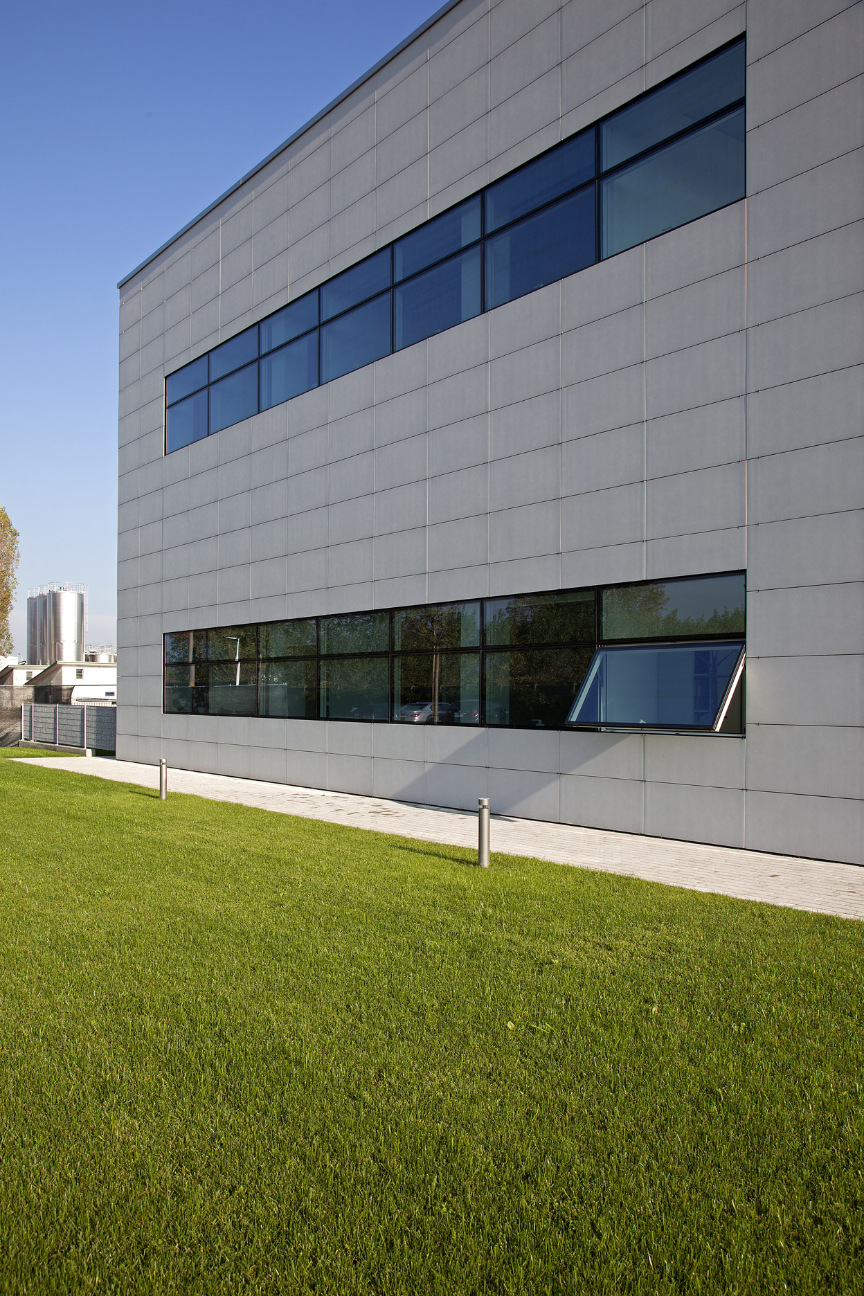 Modern Architecture: Building with grey facade, large windows, and green space.