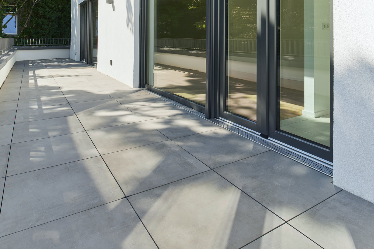 Modern terrace with light grey outdoor tiles.