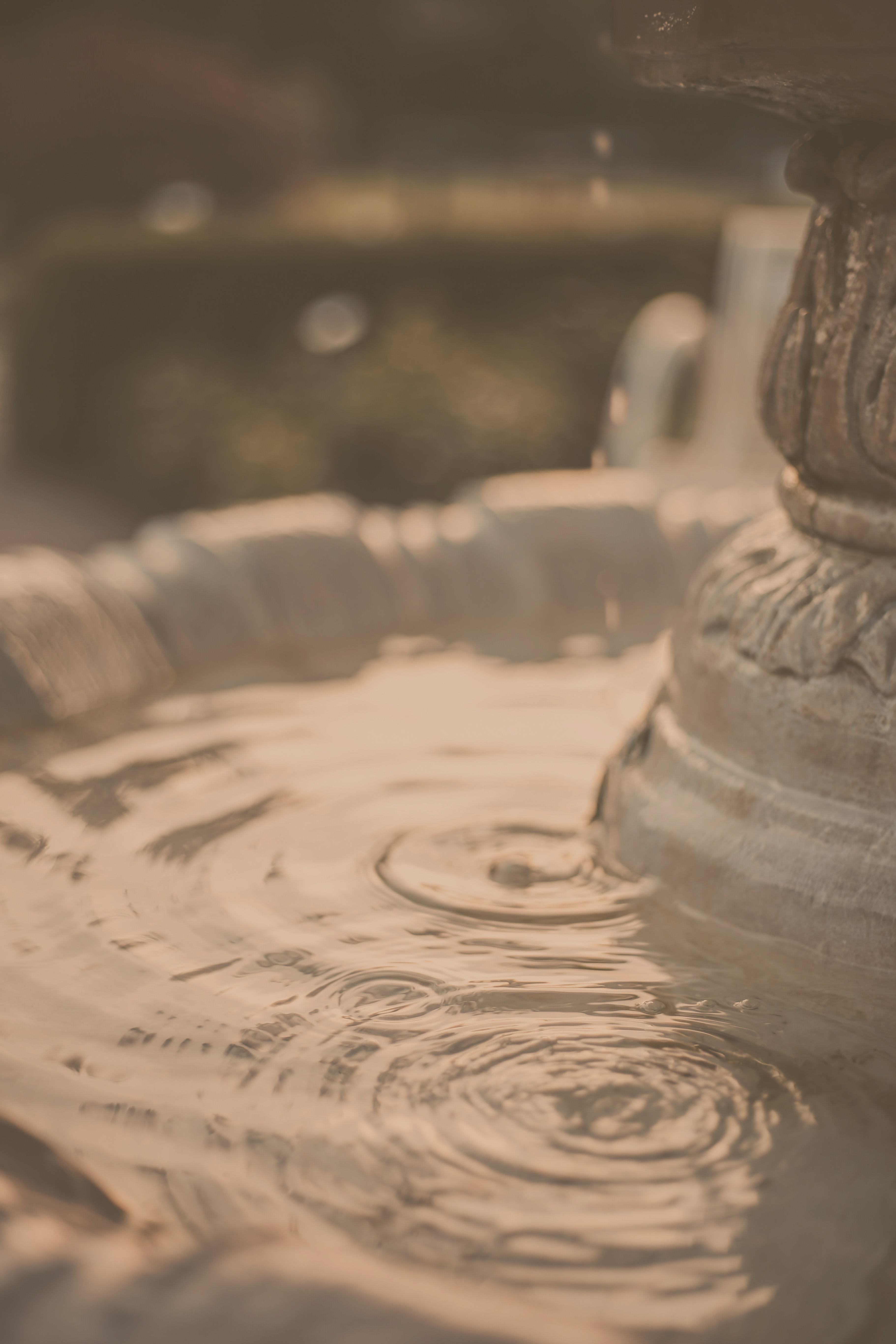 Close-up of a high-quality stone fountain with water droplets and ripples.