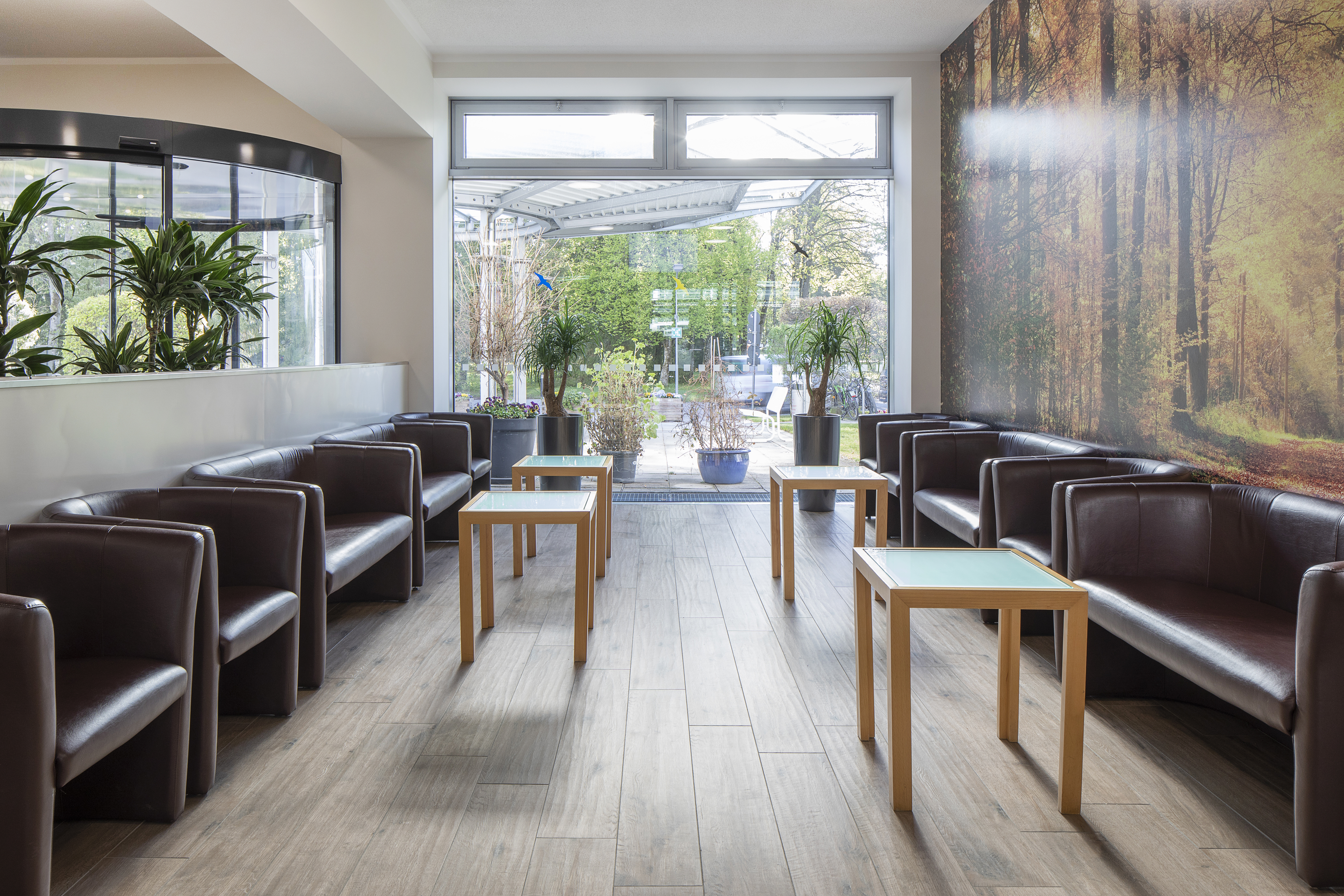 Modern reception area with light wood-look tiles and comfortable seating.