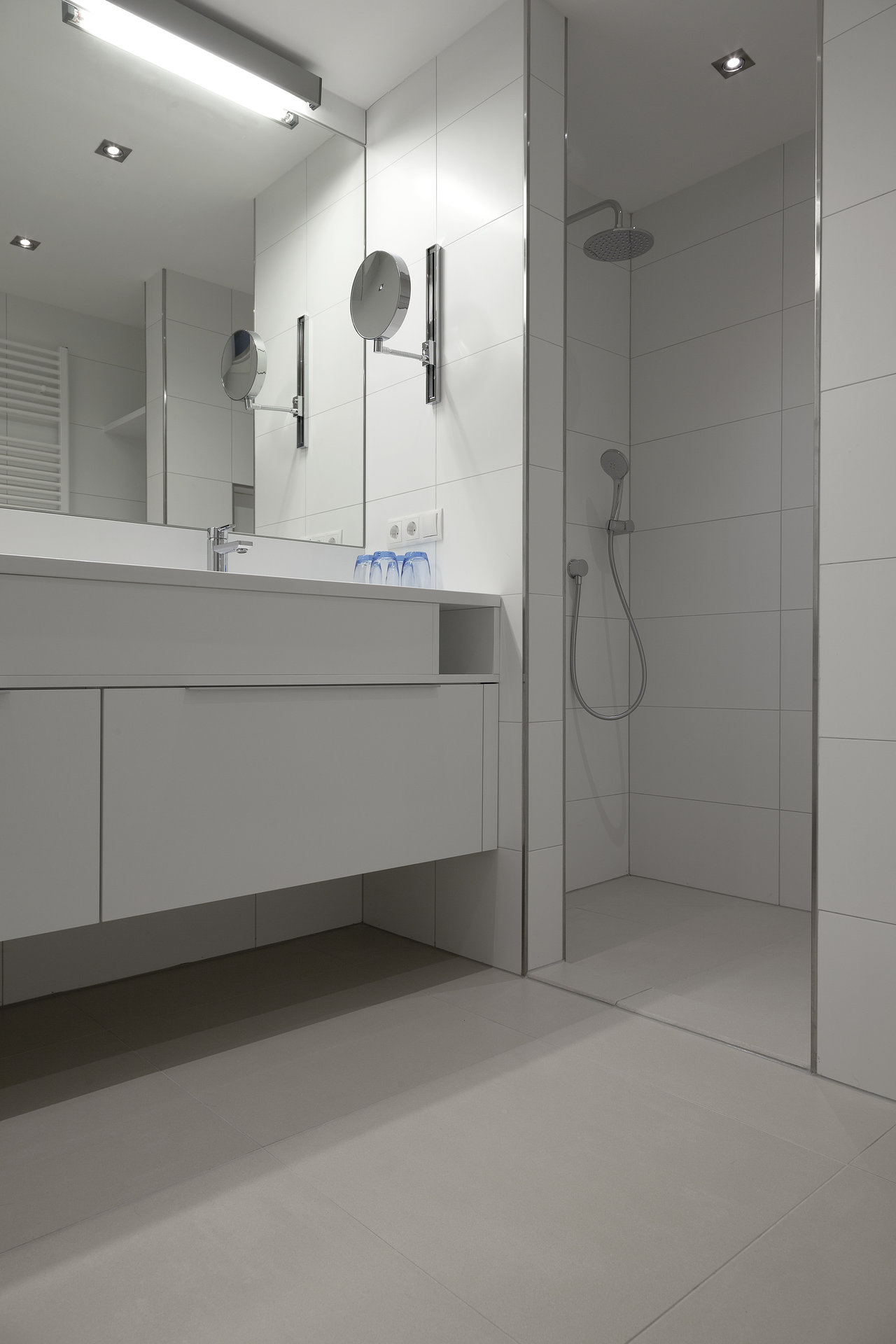 Modern bathroom with large-format, light wall and floor tiles.