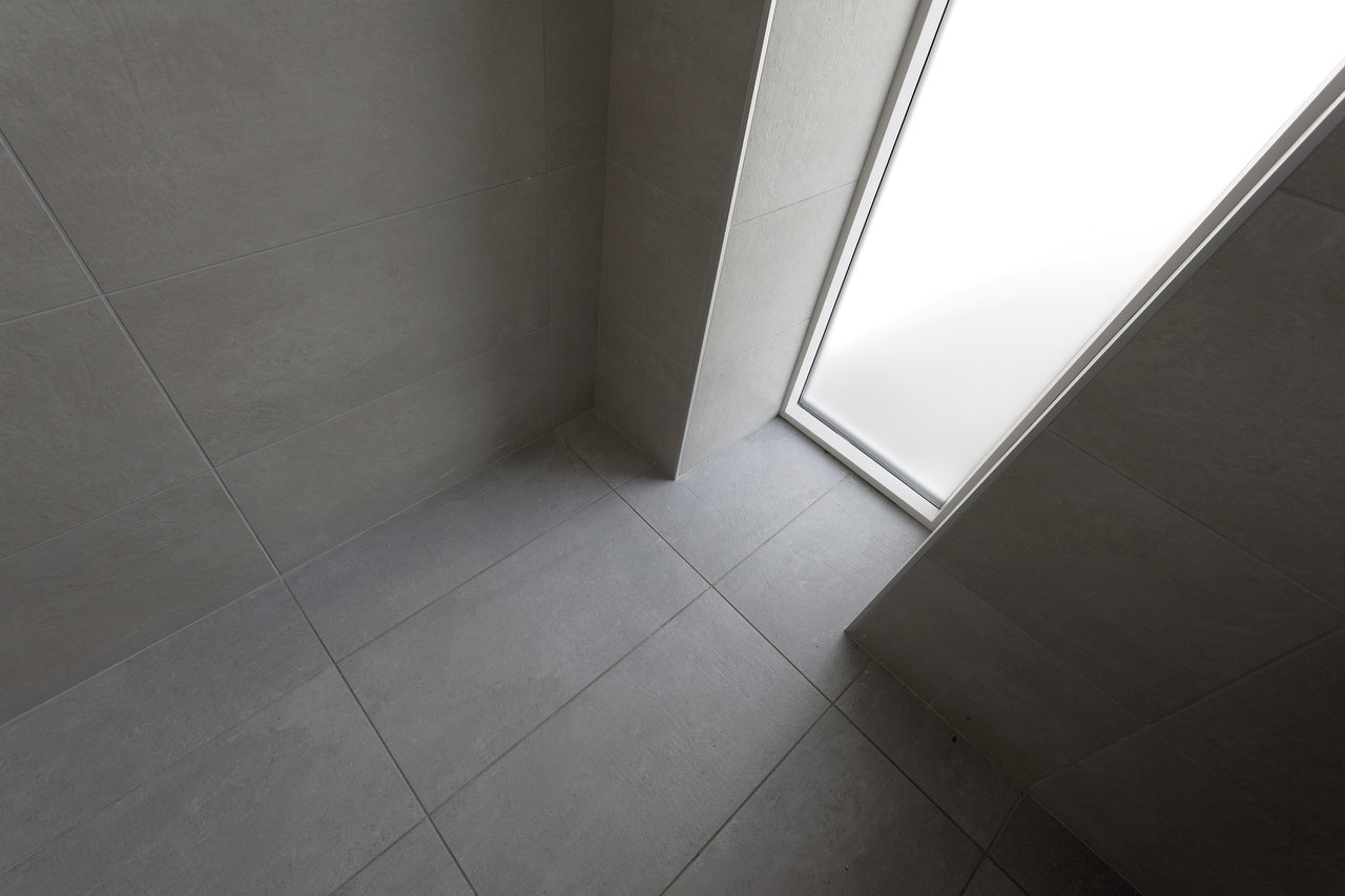 Light, large-format grey tiles for indoor walls and floors.