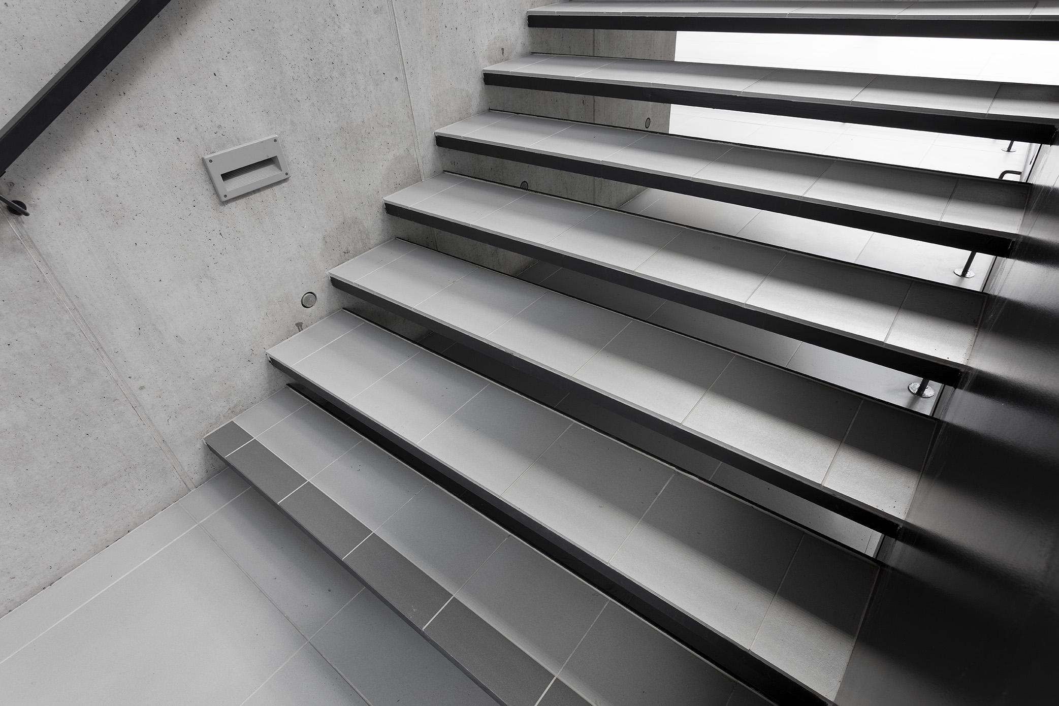Modern staircase with grey tiles, ideal for indoor use.