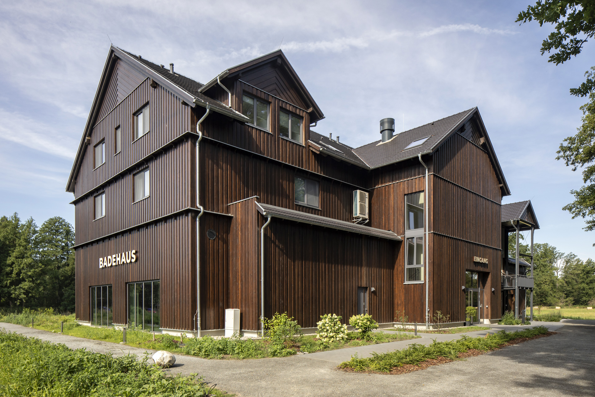 Modern bathhouse with dark wood facade, ideal for premium indoor and outdoor tiles.