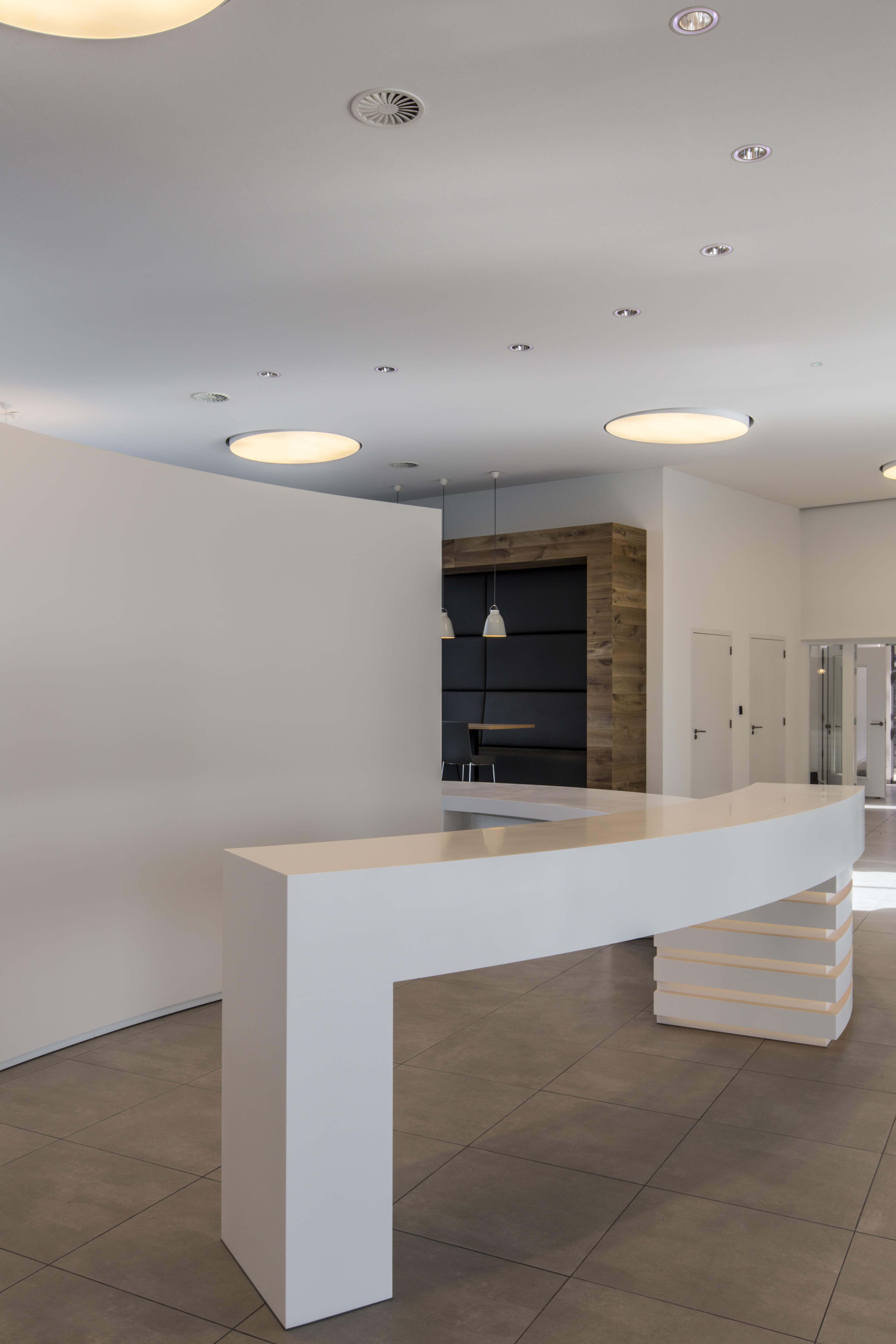 Large-format grey floor tiles in a modern reception area.