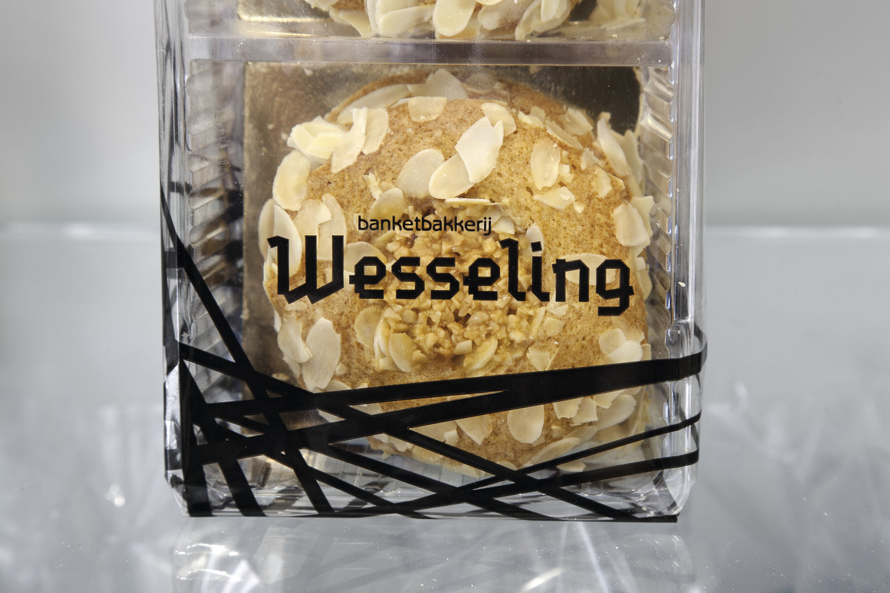 Almond pastries in a transparent box from 'banketbakkerij Wesseling', decorated with black ribbons.