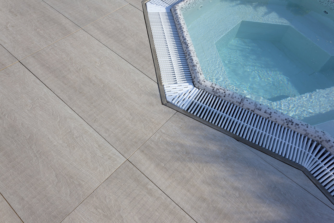 Light wood-effect outdoor tiles for pool surround.