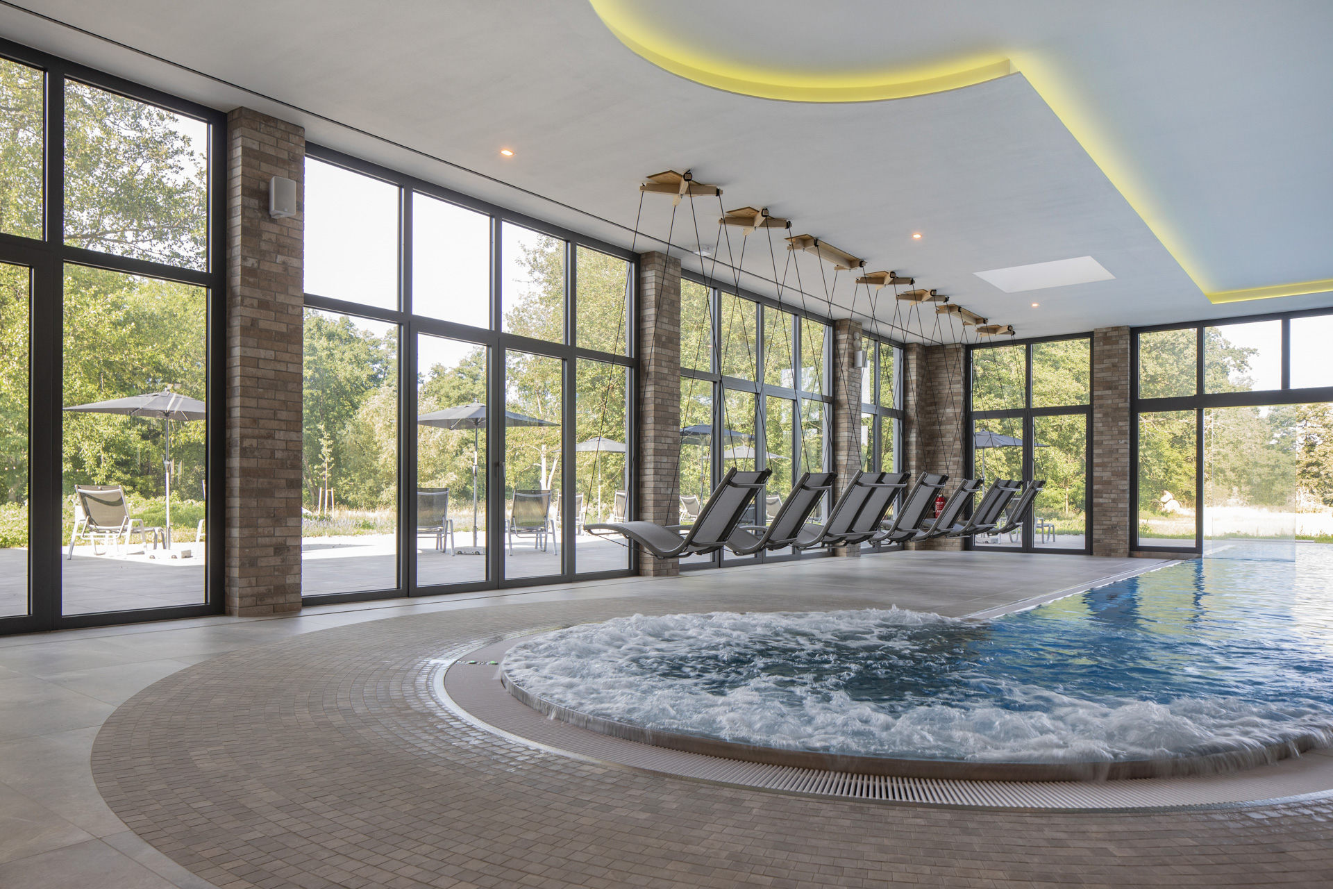 Exclusive indoor pool with whirlpool and stylish brick and natural stone look tiles.