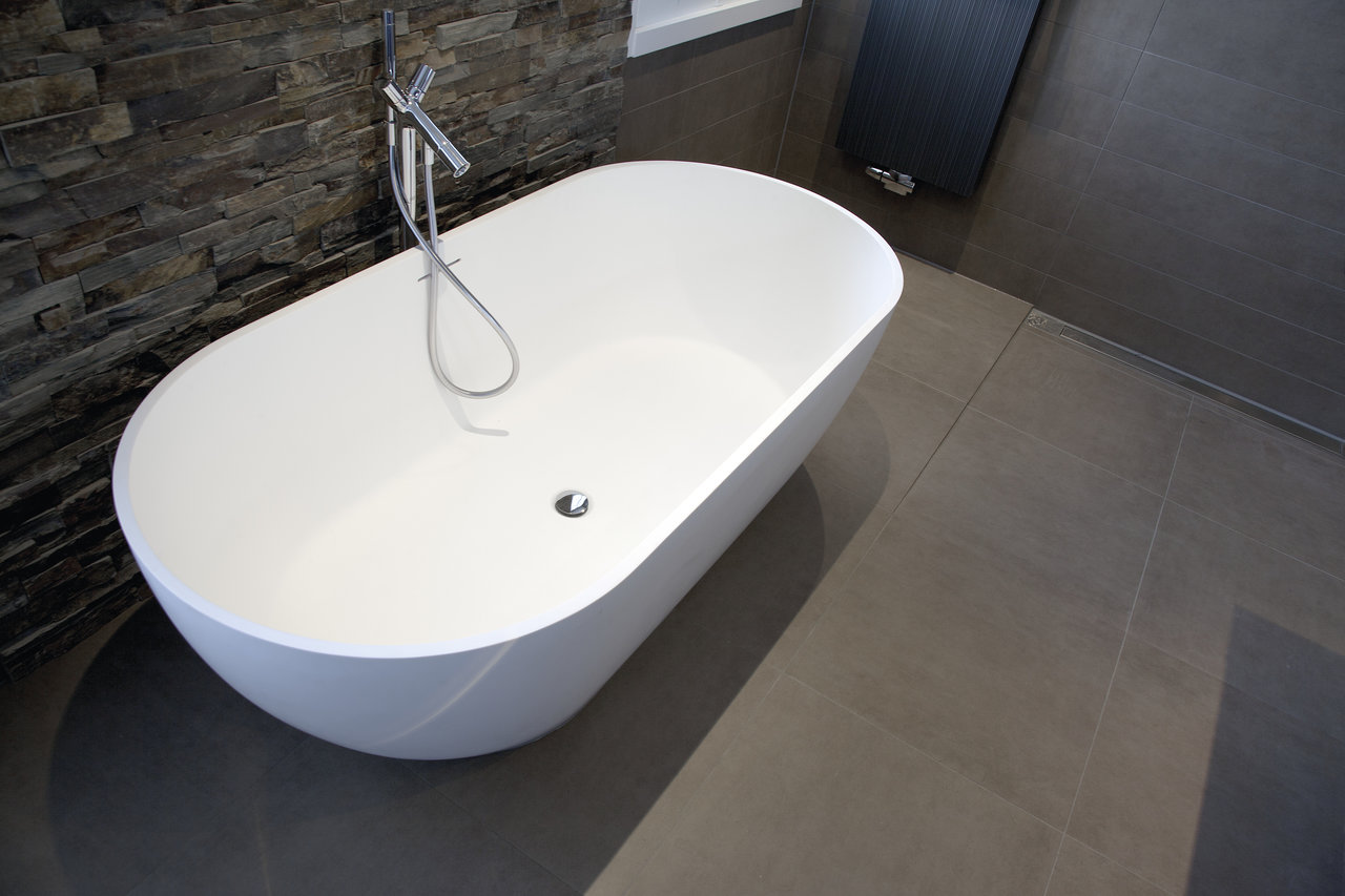High-quality dark tiles in a modern bathroom with a freestanding bathtub.