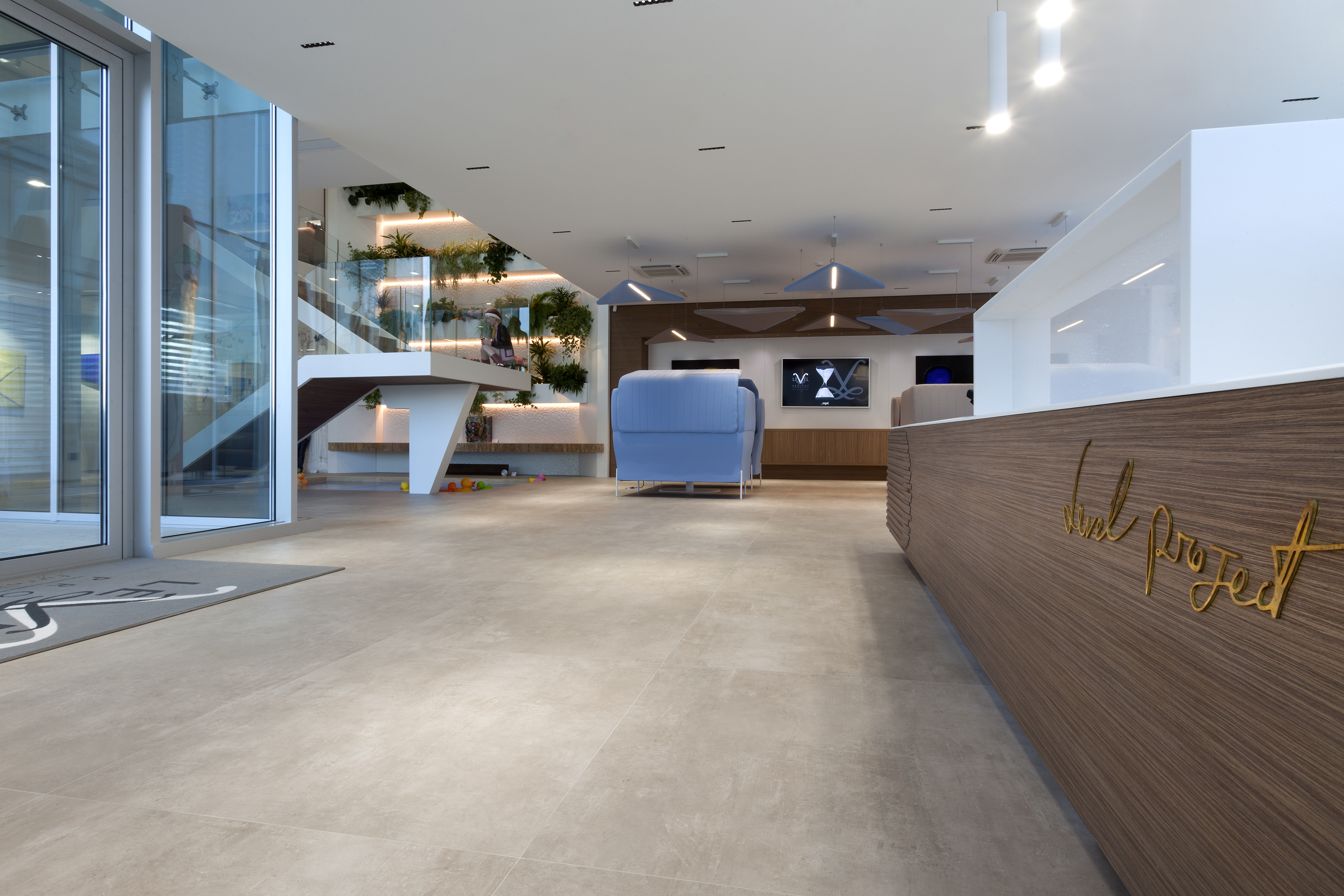 Light, large-format floor tiles in a modern reception area.