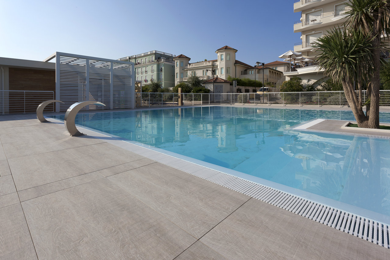 High-quality light grey outdoor tiles by the pool with water features.
