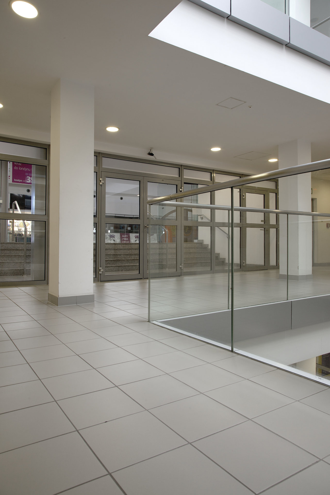 Modern, light grey floor tiles in a light-filled foyer.