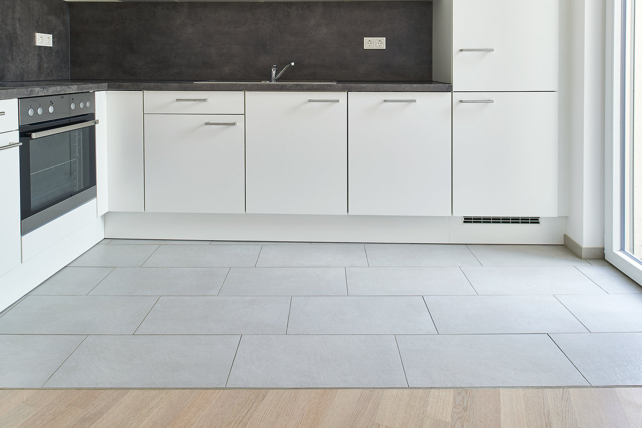 Light grey rectangular floor tiles in a modern kitchen.