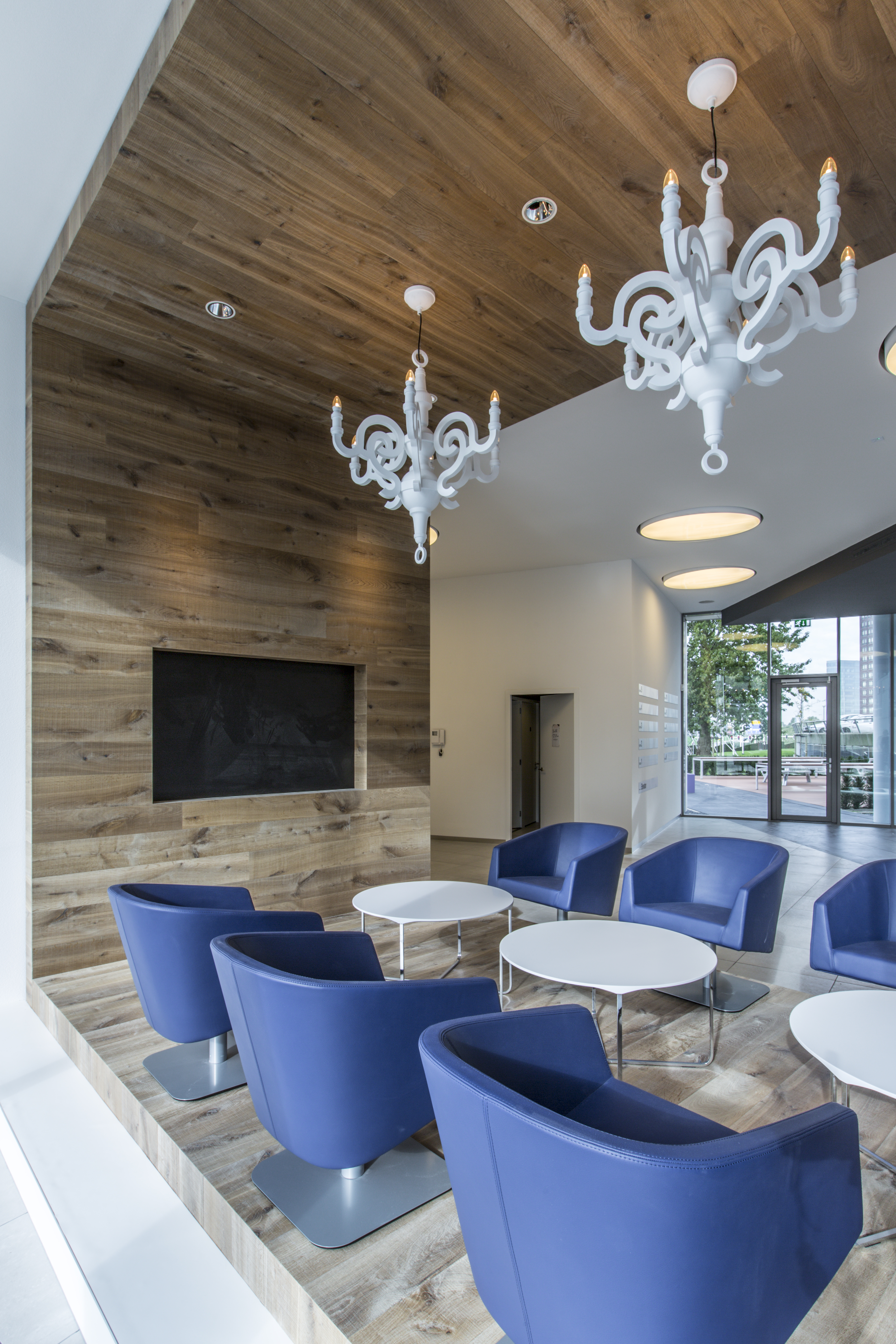 Modern lounge area with wood-look tiles on floor and wall.