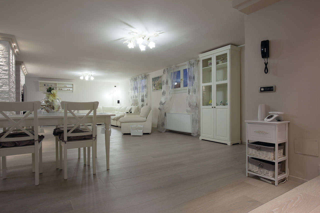 Bright living and dining area with modern, light grey wood-effect tiles.