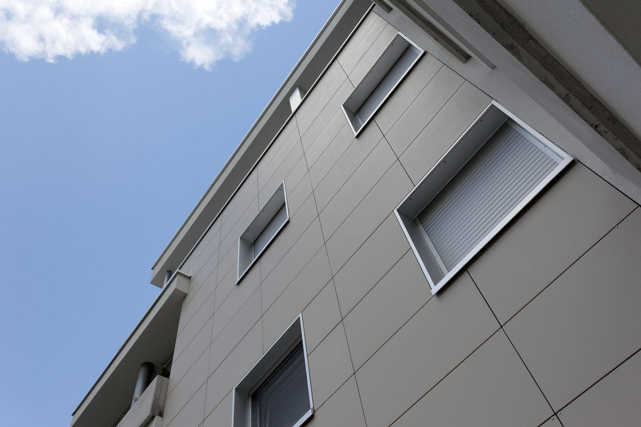 Modern building facade with light grey outdoor tiles.