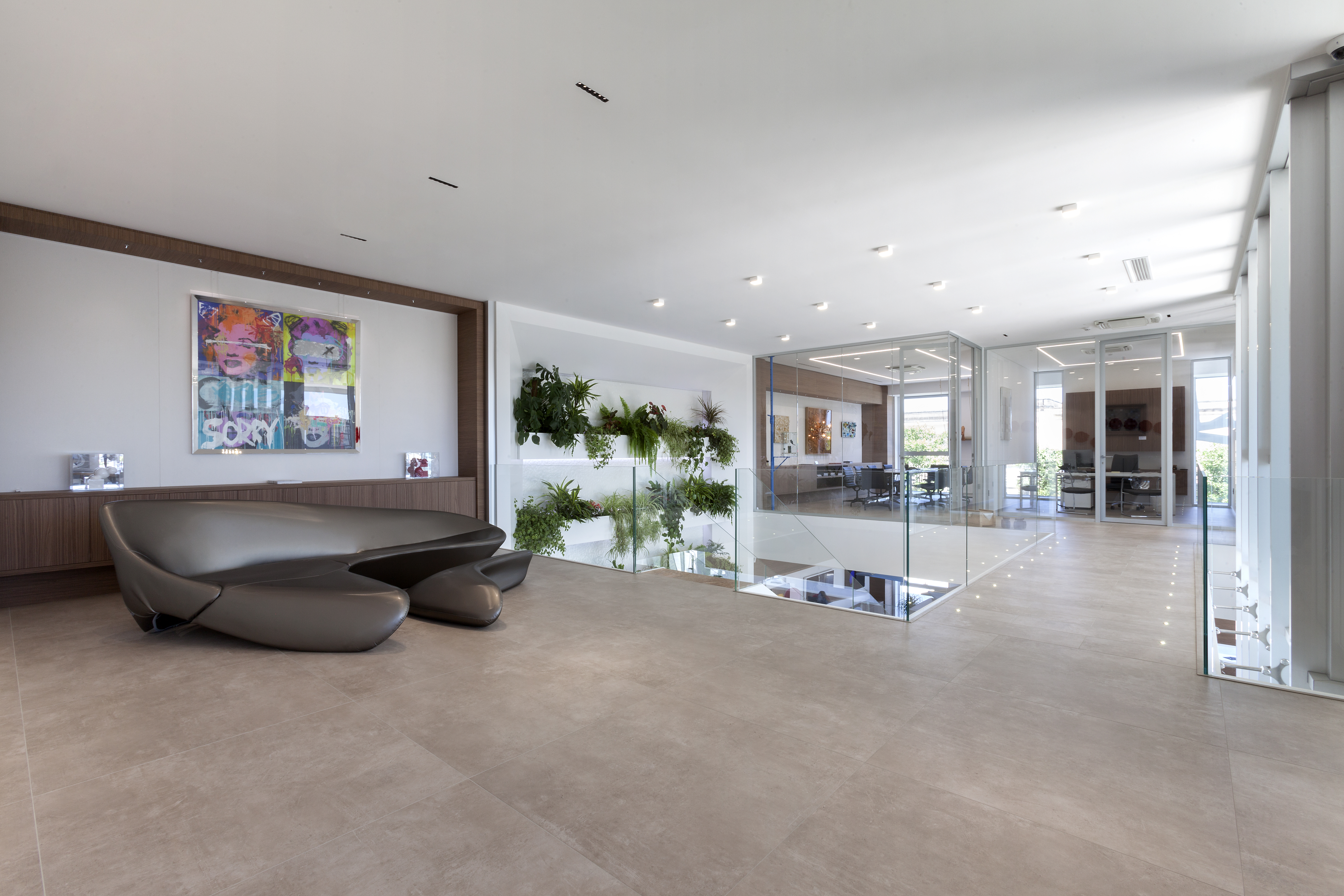 Large-format, light tiles in a modern reception with designer sofa.