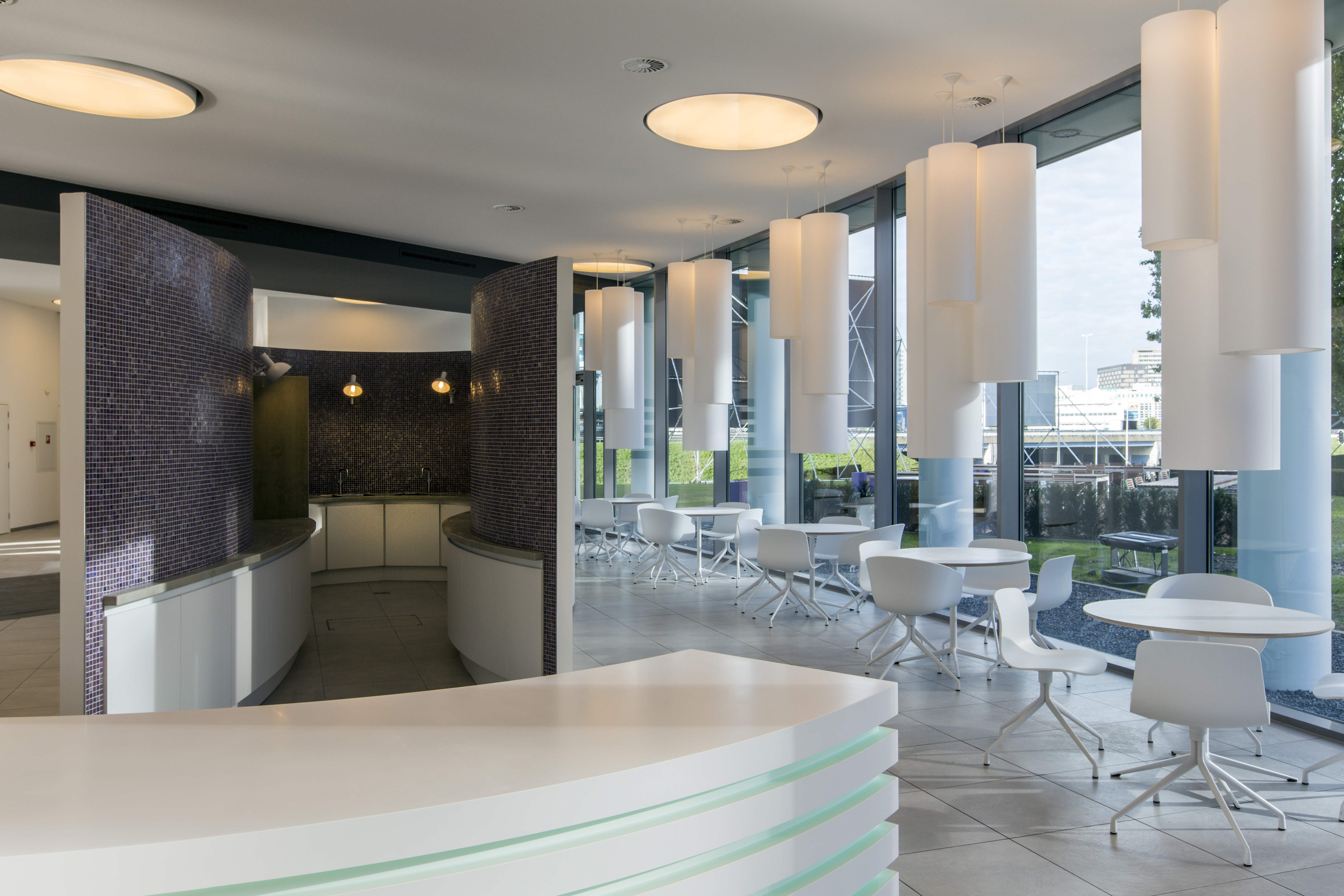 Modern lounge area with light floor tiles and dark mosaic wall.