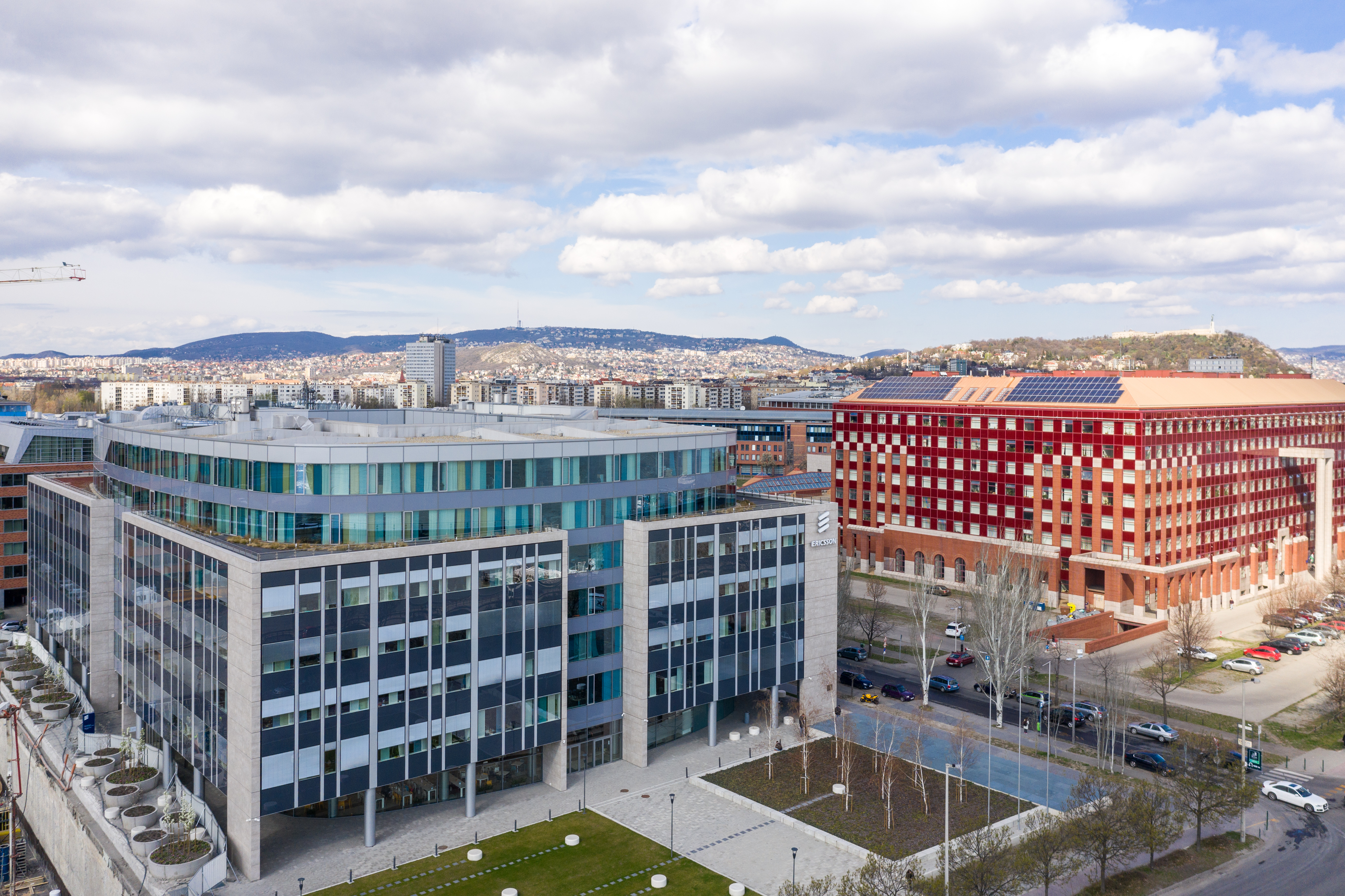Modern city view with glass facades, red brick building and urban square.