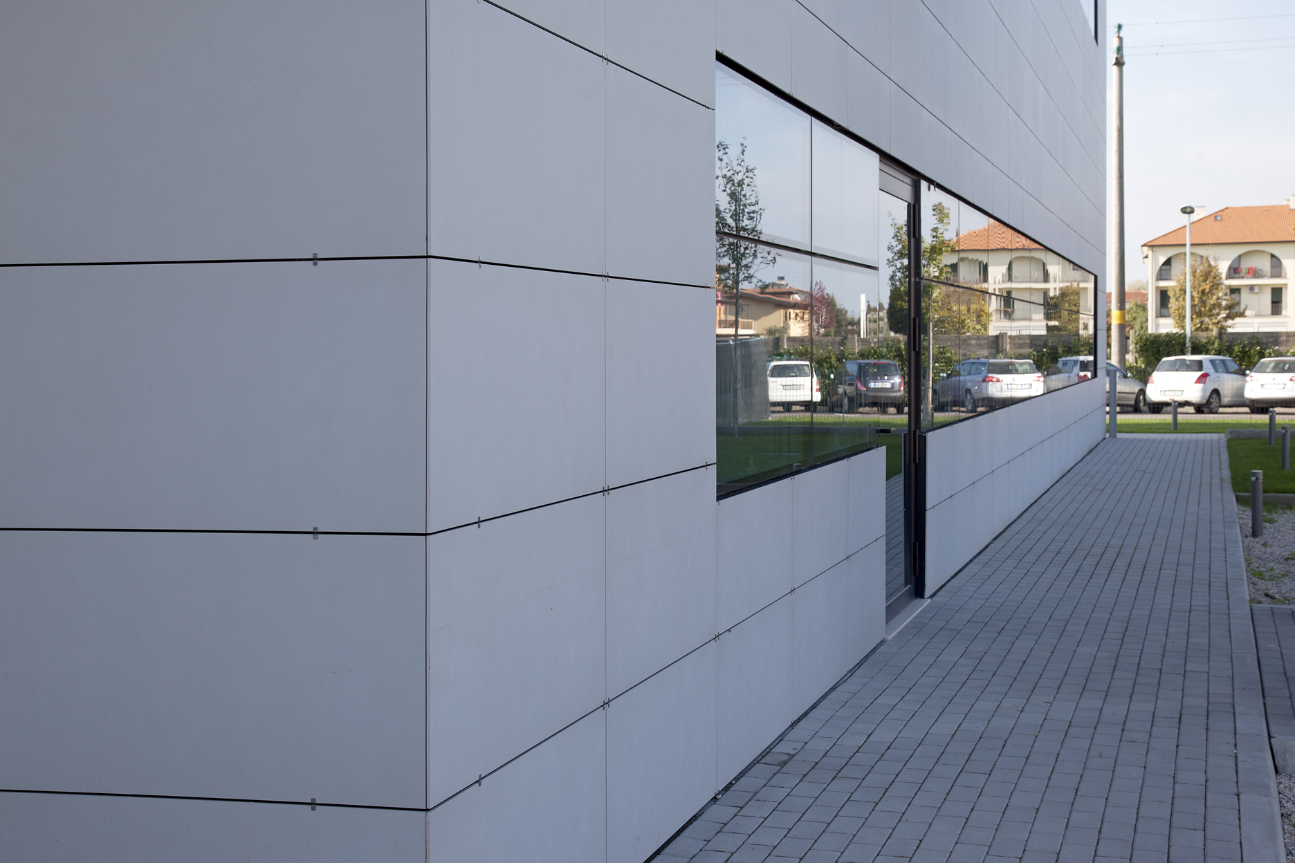 Light porcelain tiles on a modern building facade, ideal for outdoor areas.