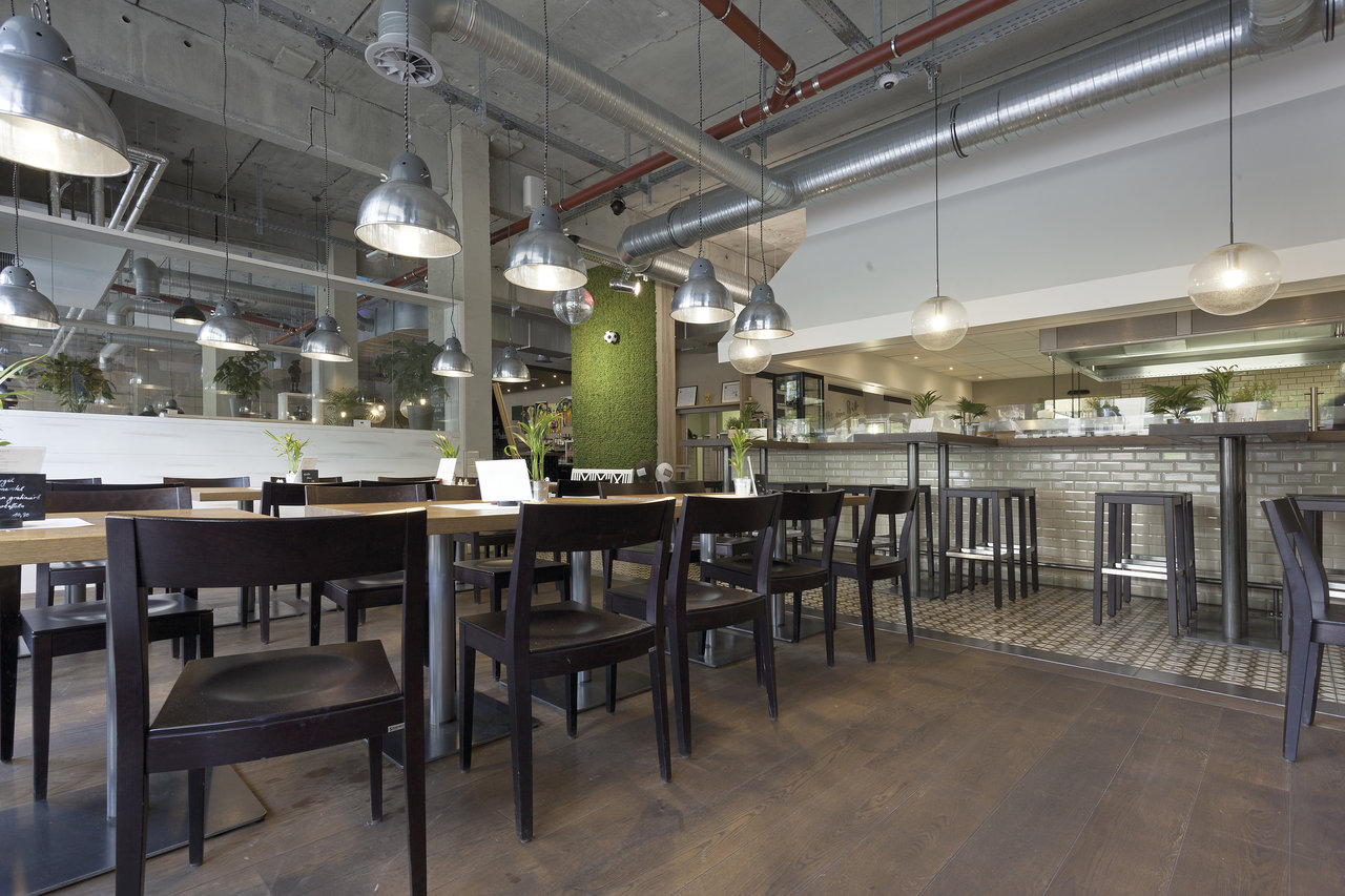 Dining area with dark wood-look tiled floor and urban industrial design.
