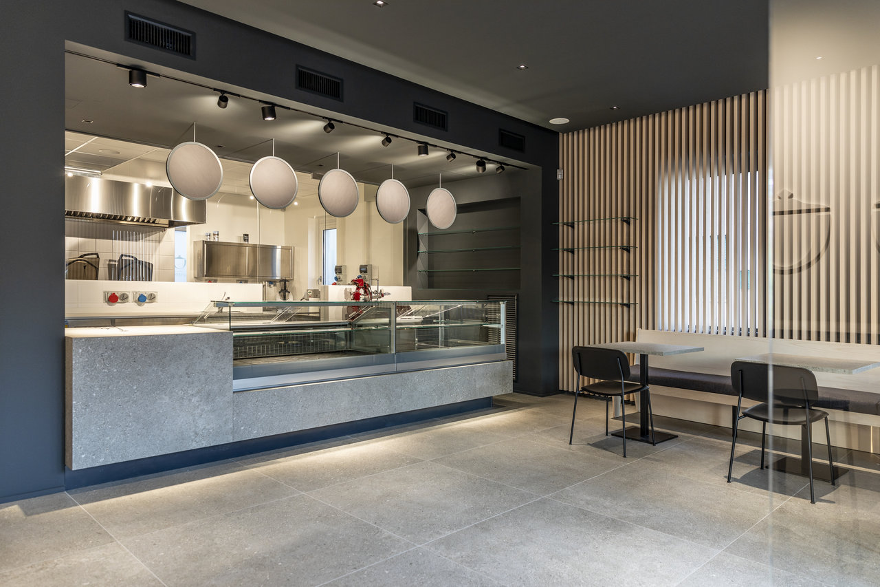 Modern restaurant area with large grey floor and counter tiles.