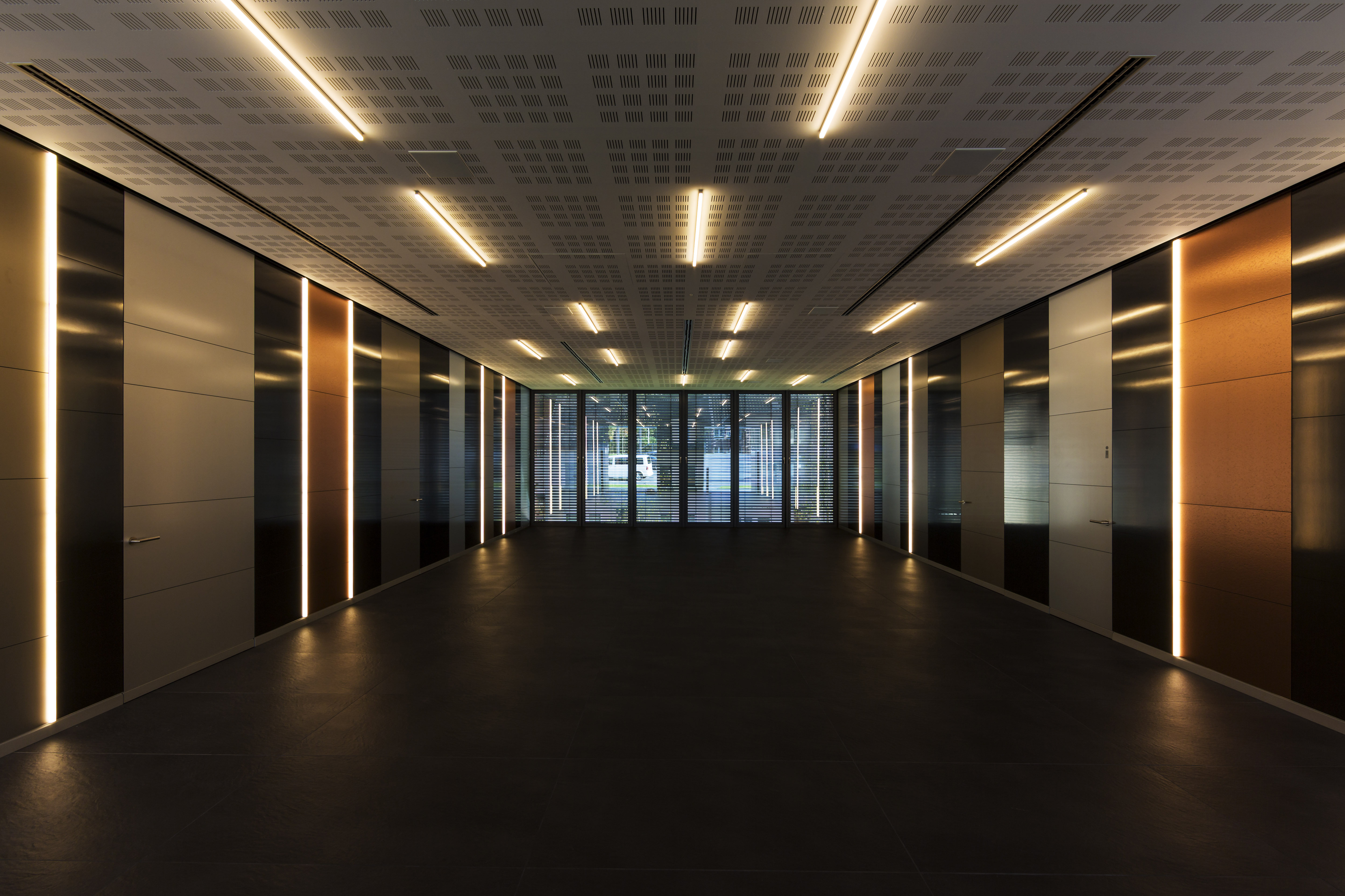 Spacious entrance area with dark floor tiles, elegant wall cladding, and LED accent lighting.
