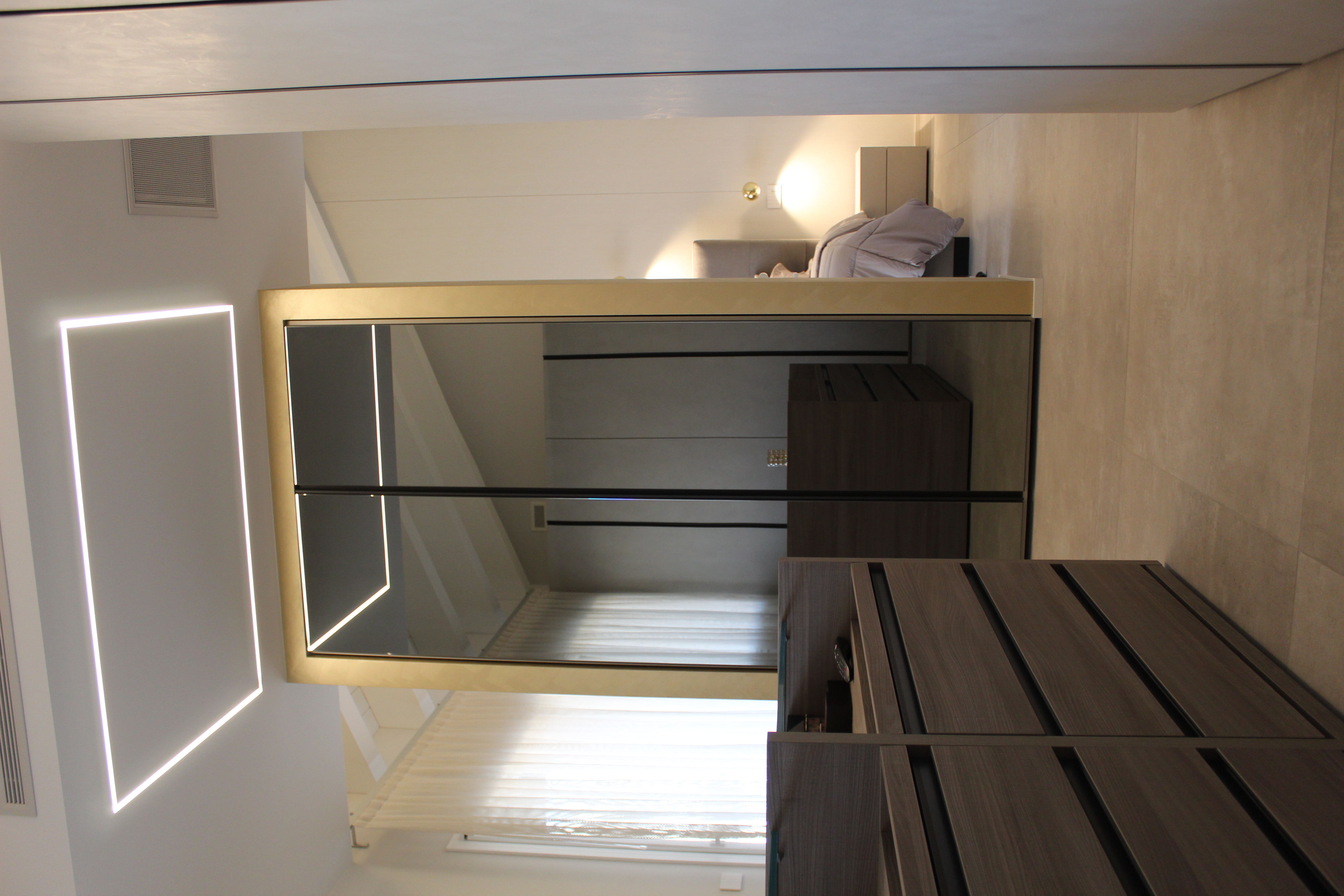 Light-coloured, large-format floor tiles create an elegant atmosphere in this modern walk-in wardrobe.