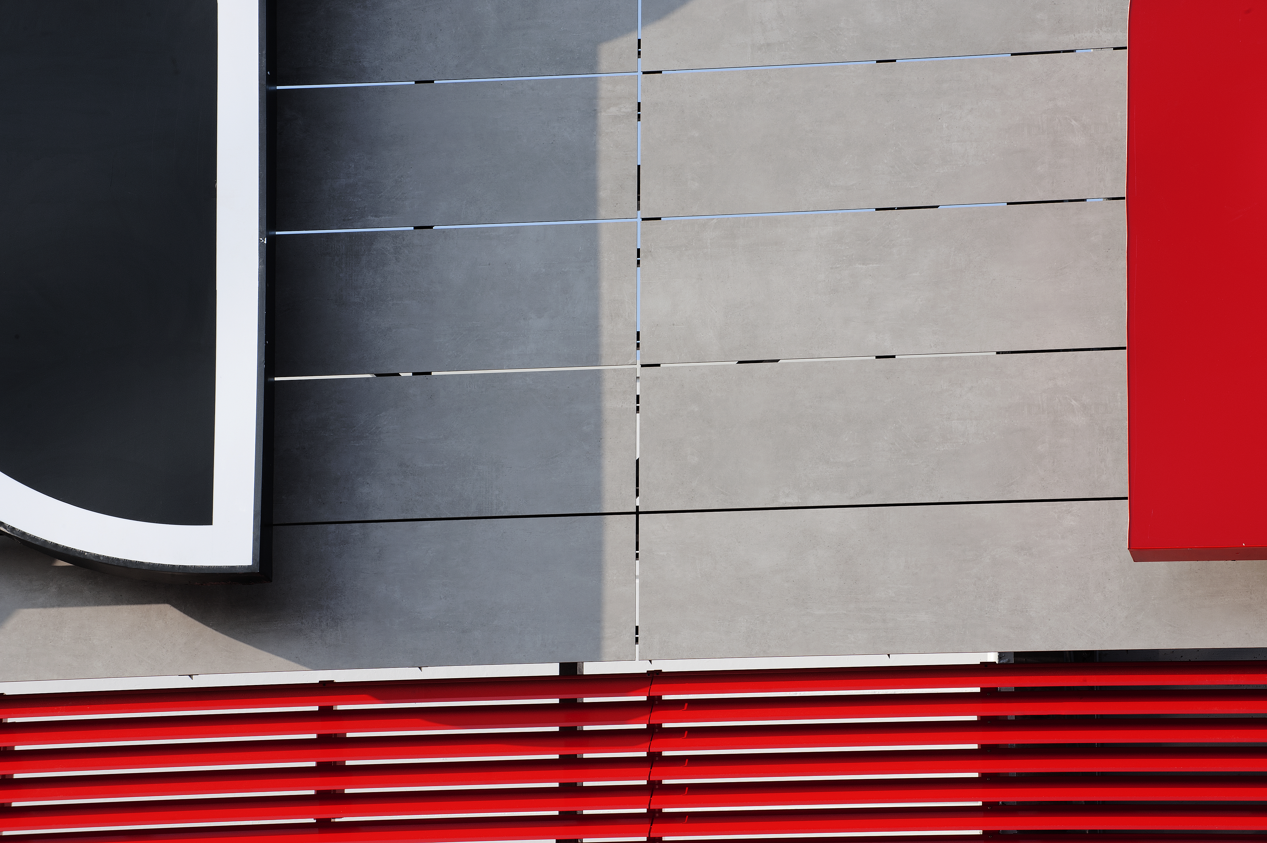 Modern grey tiled wall with red design elements and black accents.