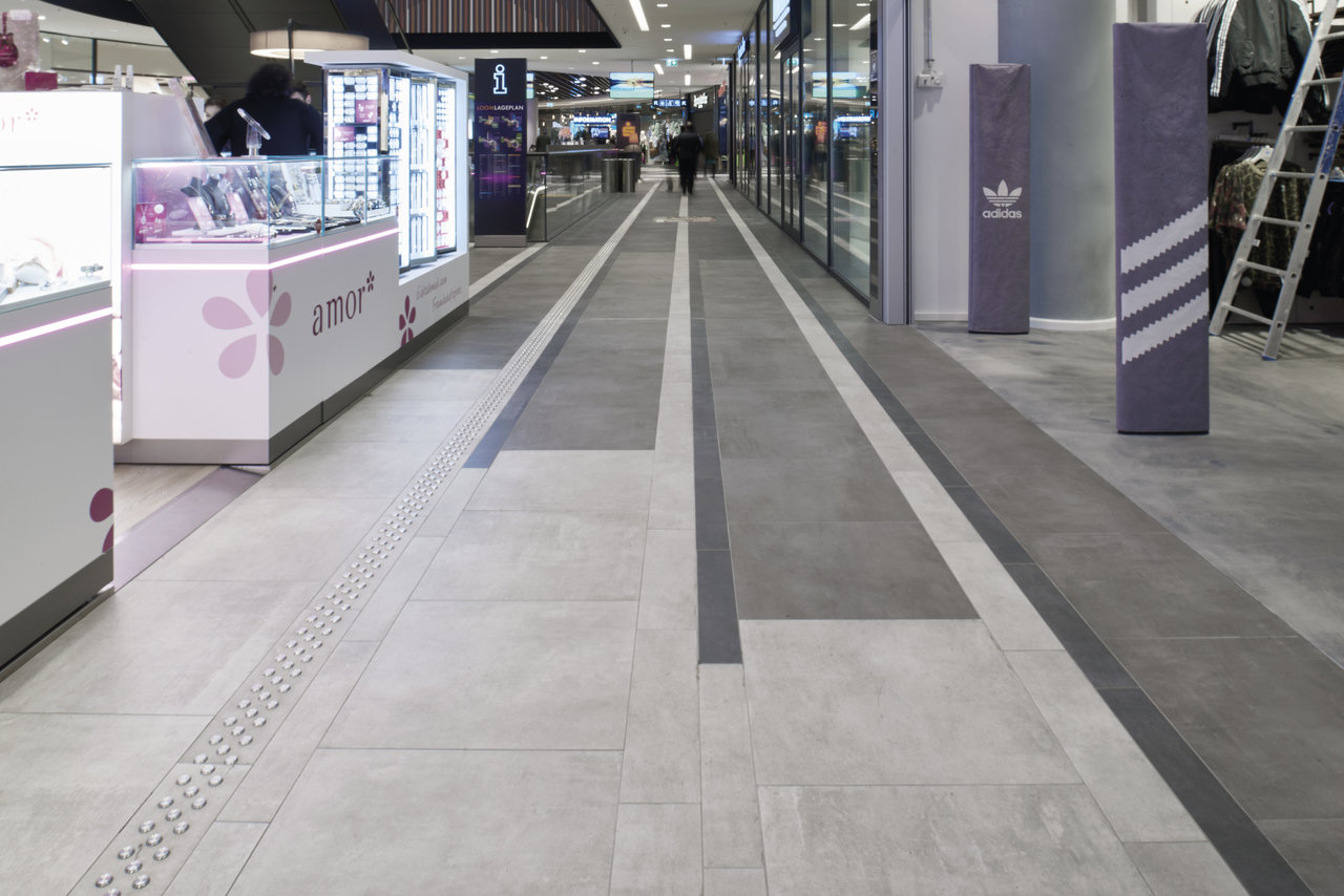 High-quality grey striped tiles in a modern shopping arcade.