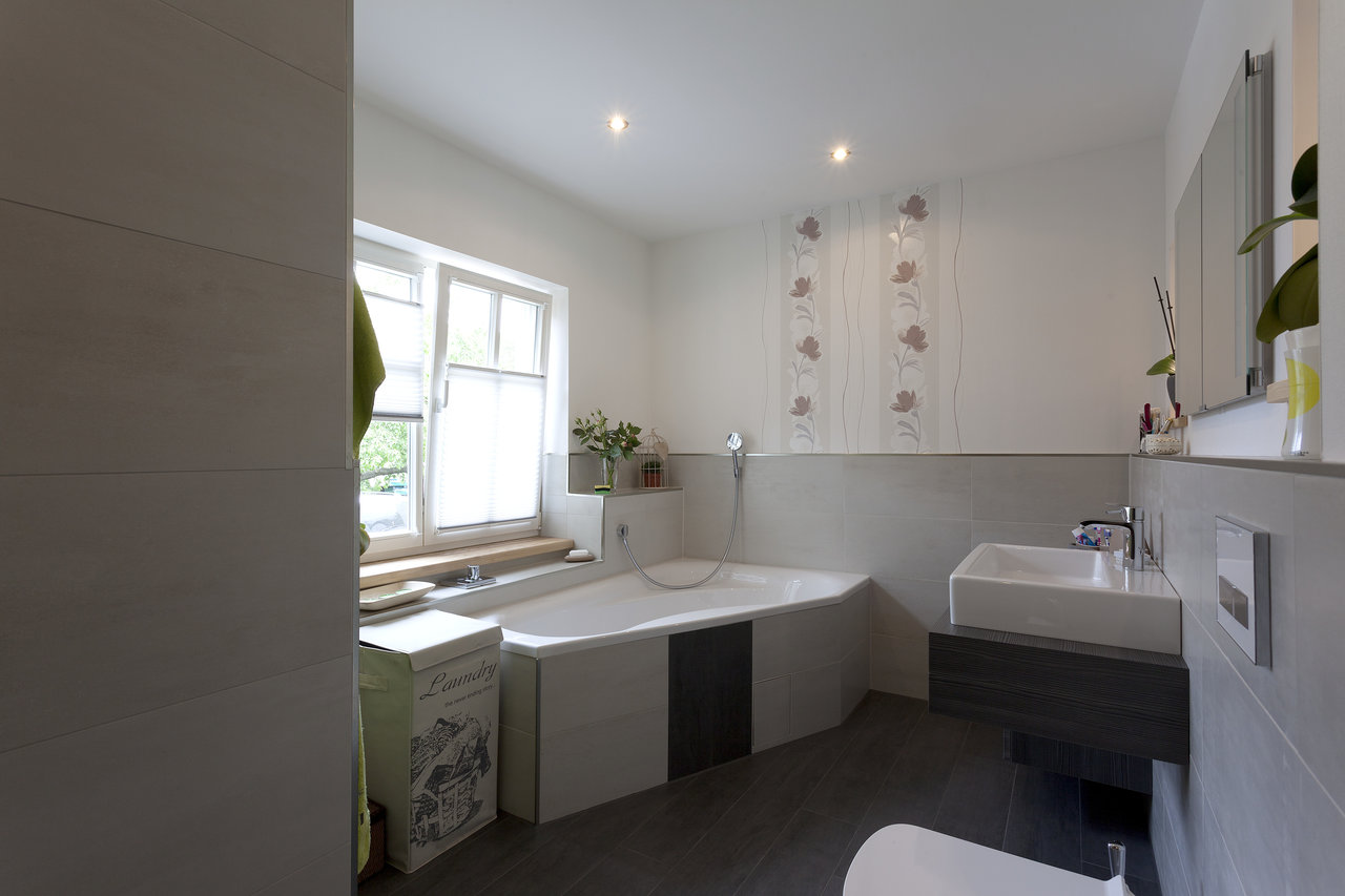 High-quality tiles in a modern bathroom: dark floor, light walls.