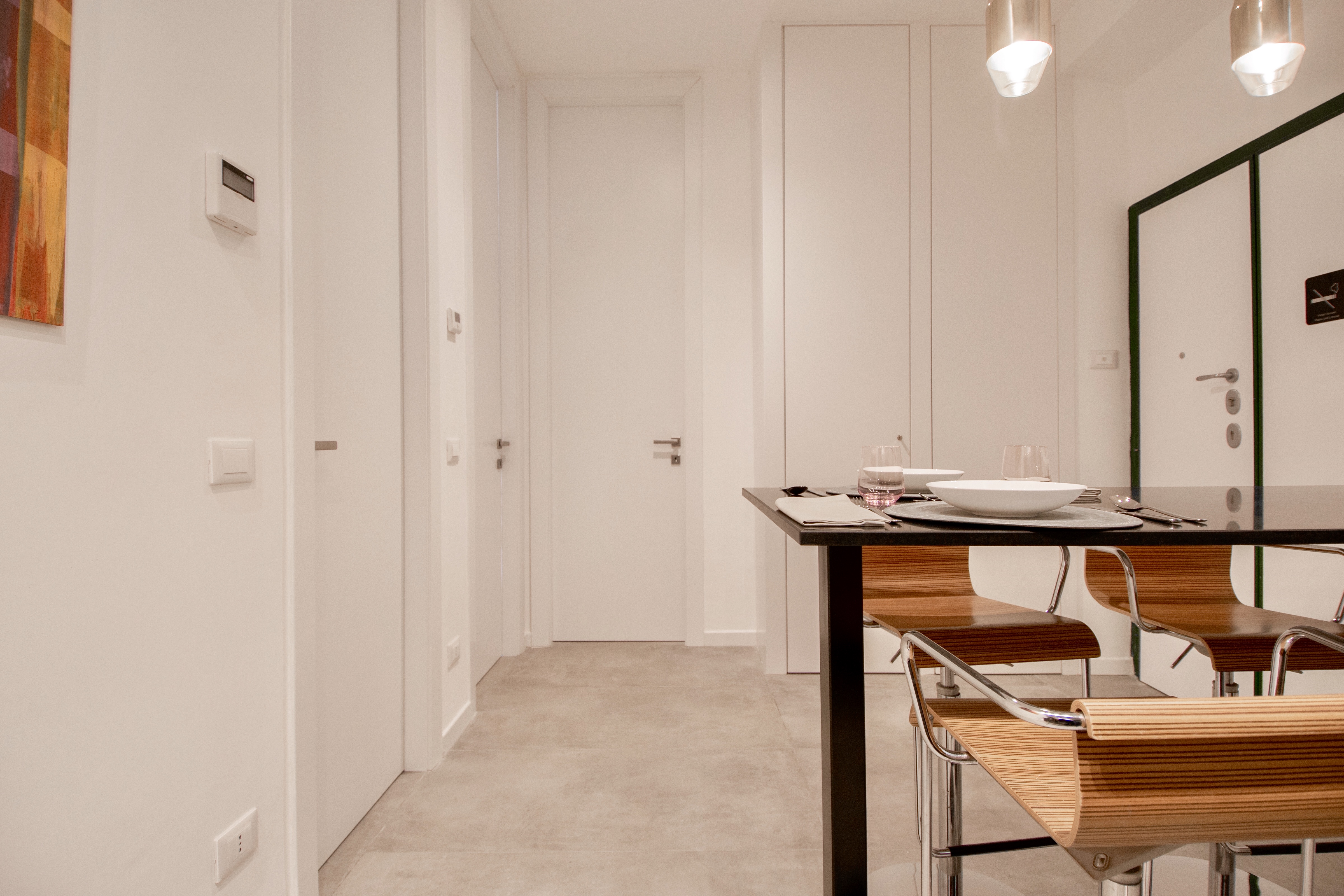 Light, large-format floor tiles in a modern living area with a dining table.