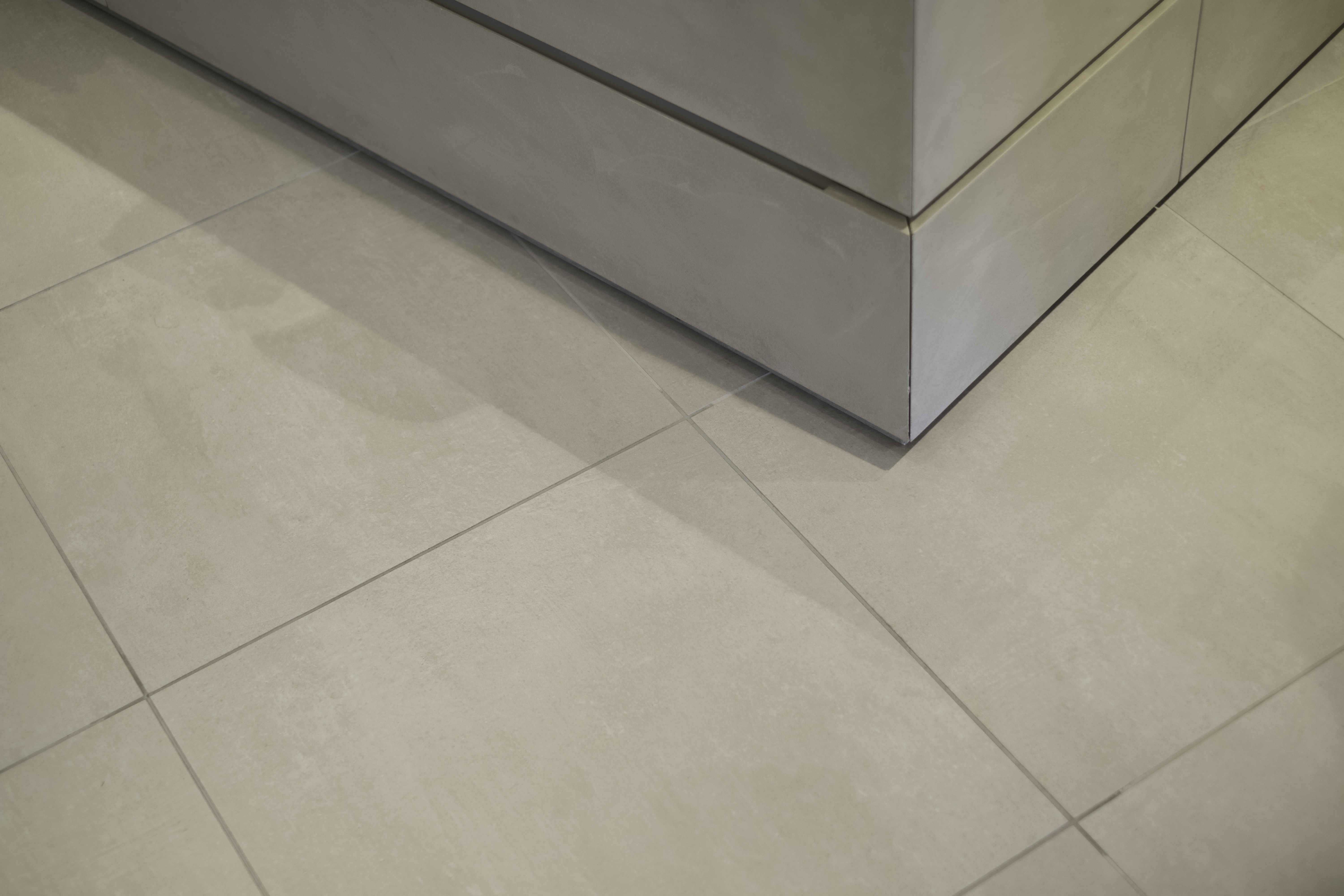 Detail shot: Light grey porcelain stoneware floor tiles with clean grout.