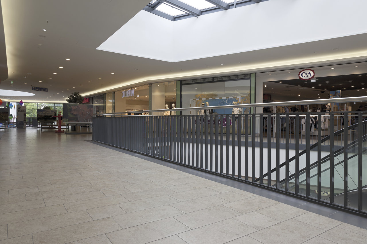 Bright, large-format indoor tiles in a modern shopping centre.