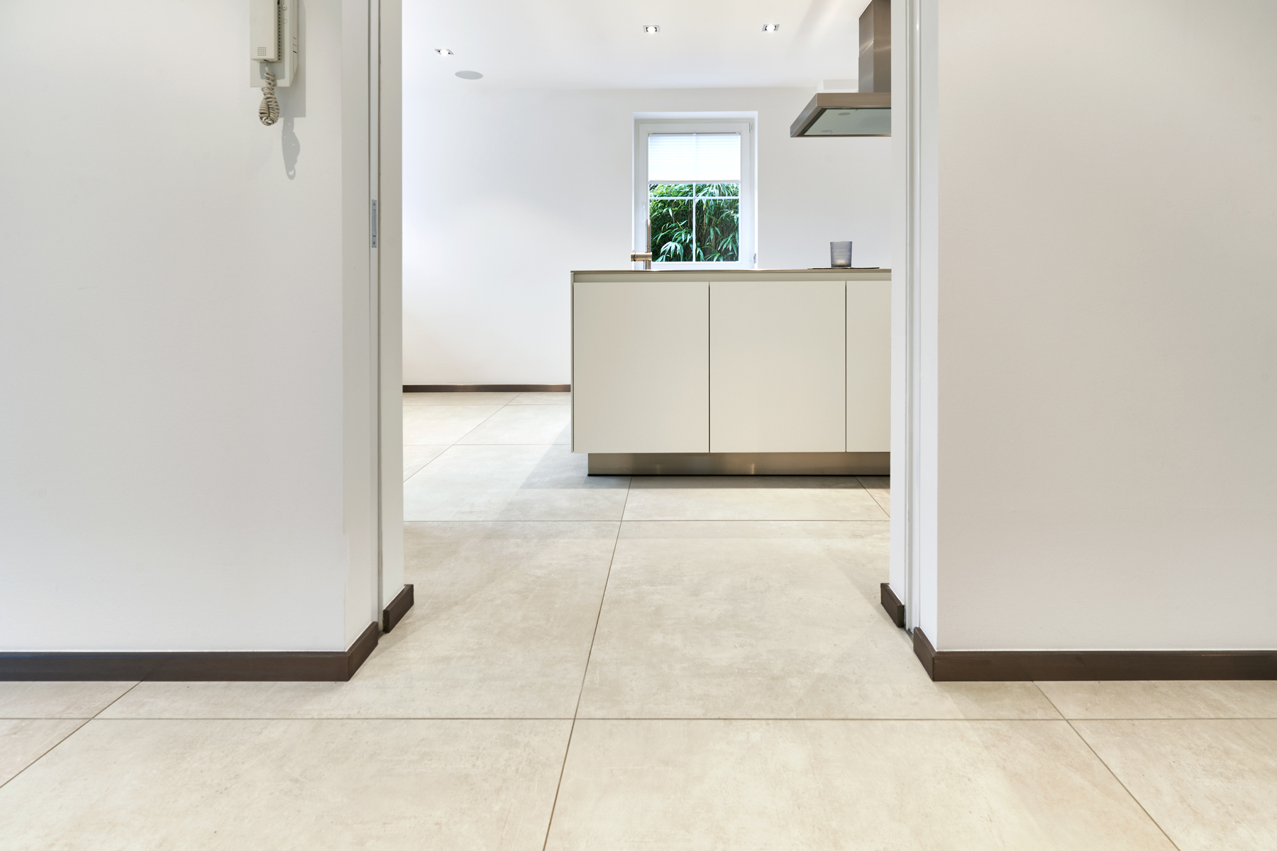 Large-format, light floor tiles in a modern kitchen-diner.