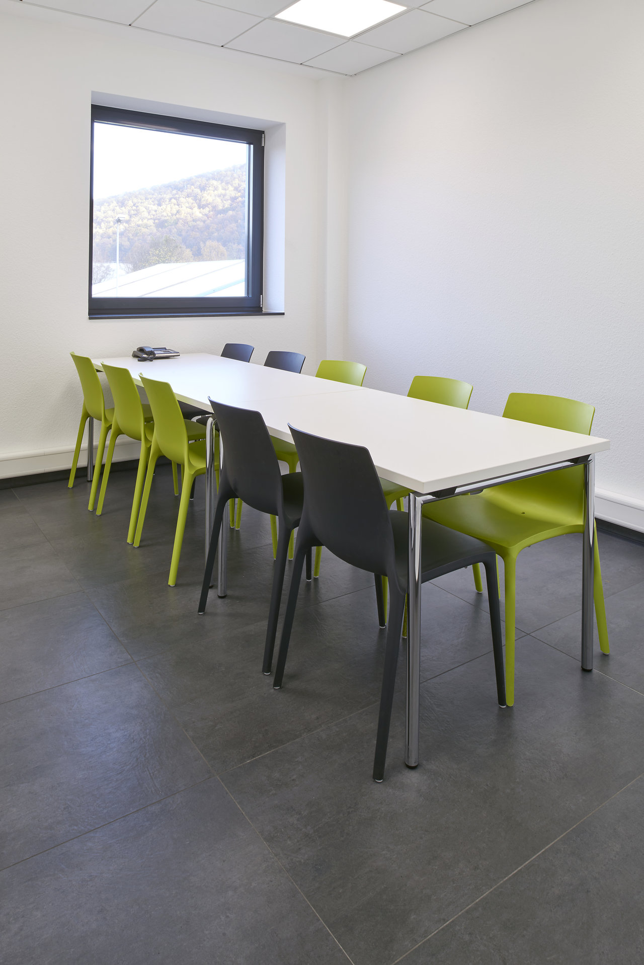 High-quality dark grey floor tiles in a modern meeting room.