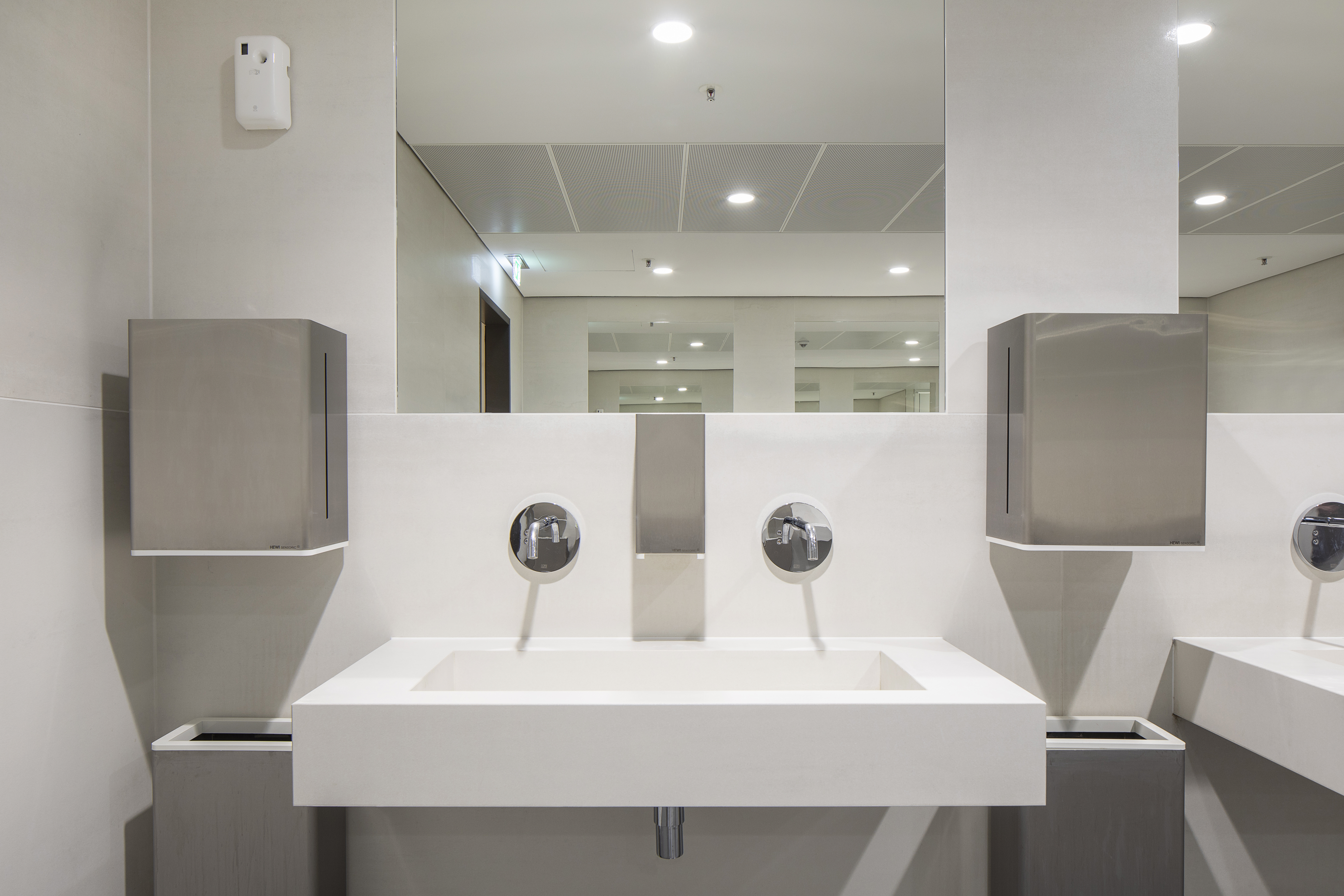 Interior with modern white wall tiles and washbasin.