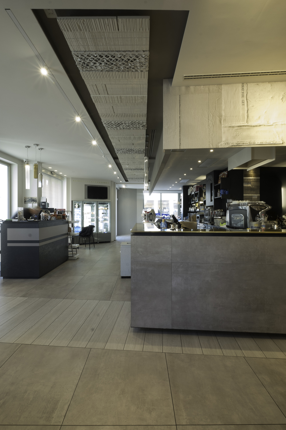 Light-coloured, large-format tiles in a modern café interior.