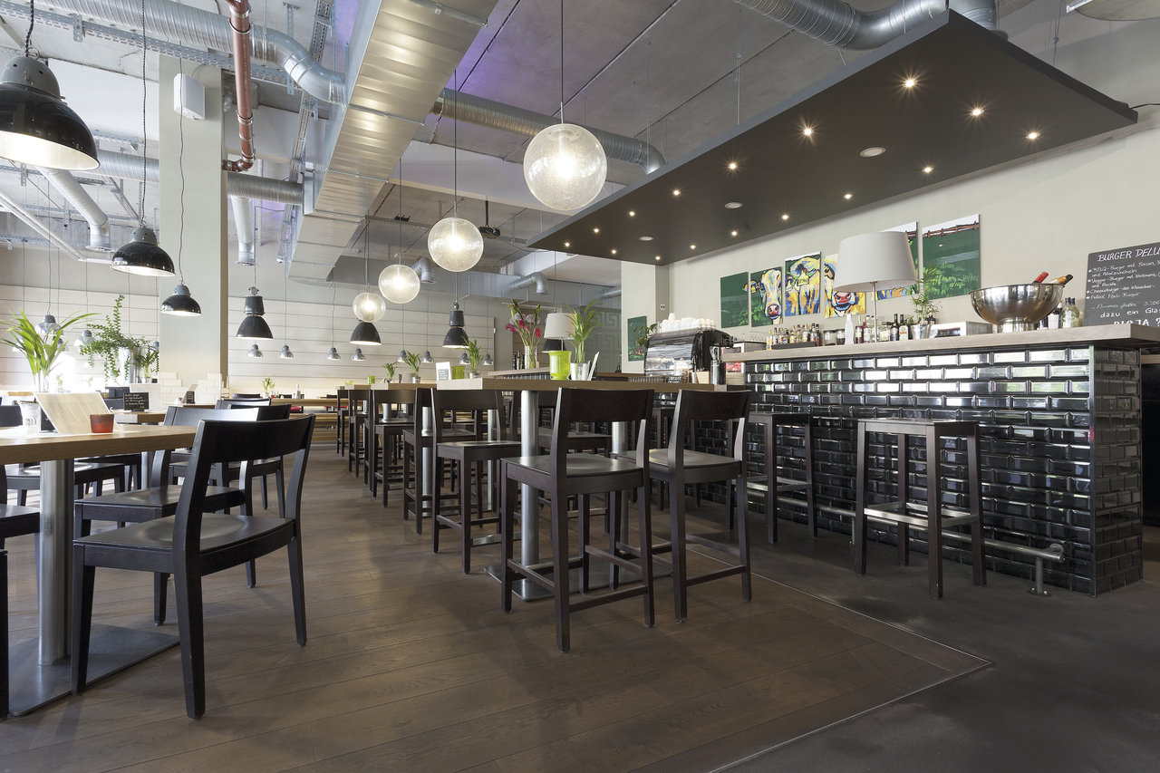 Modern dining area with dark floor tiles and glossy black subway tiles at the bar.
