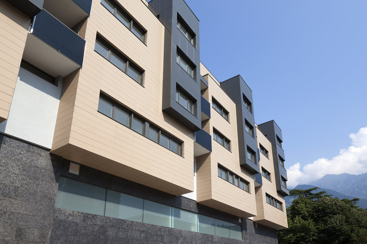 Modern building facade with light and dark large-format outdoor tiles.