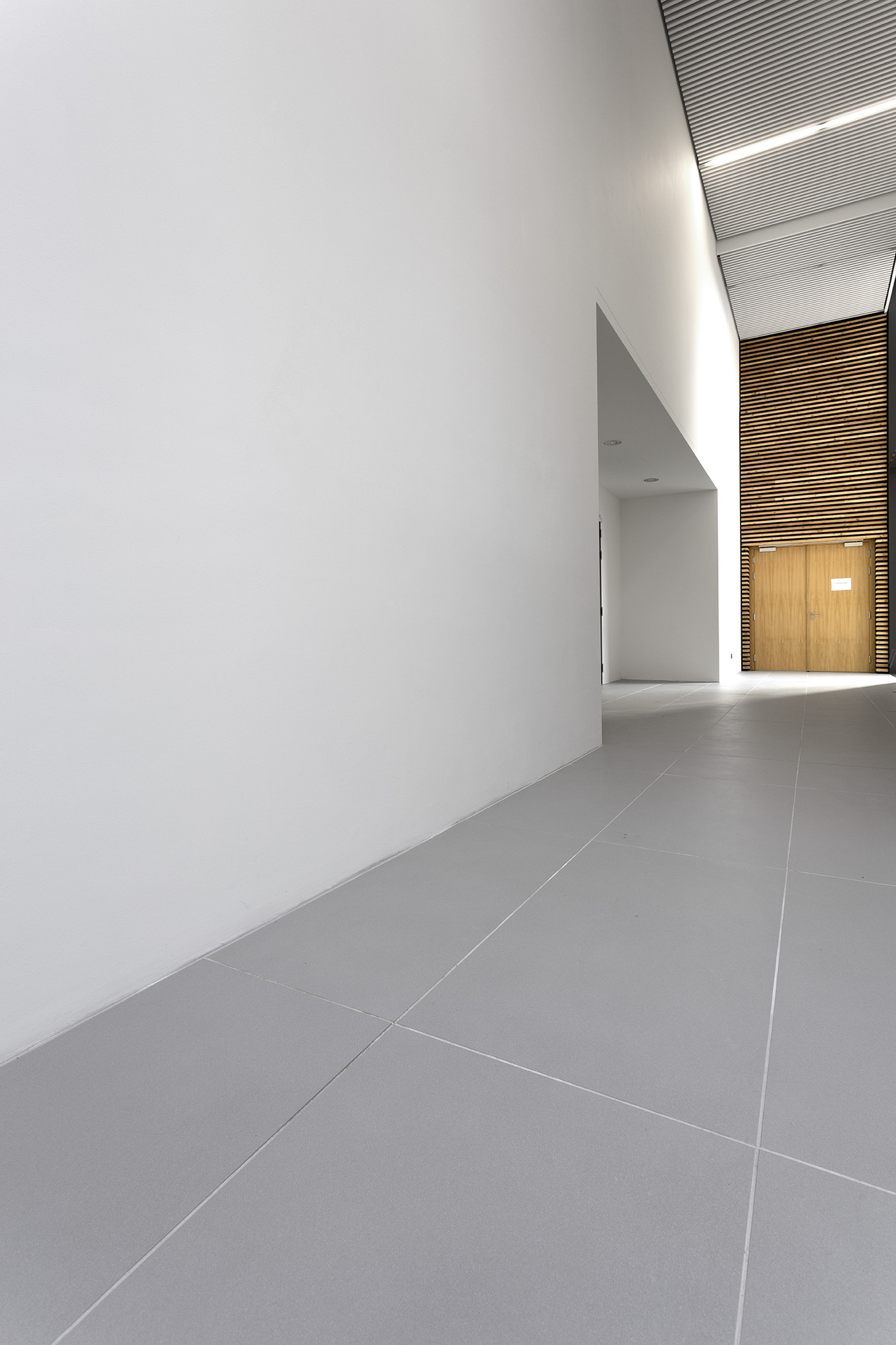 High-quality light grey floor tiles in a modern hallway.
